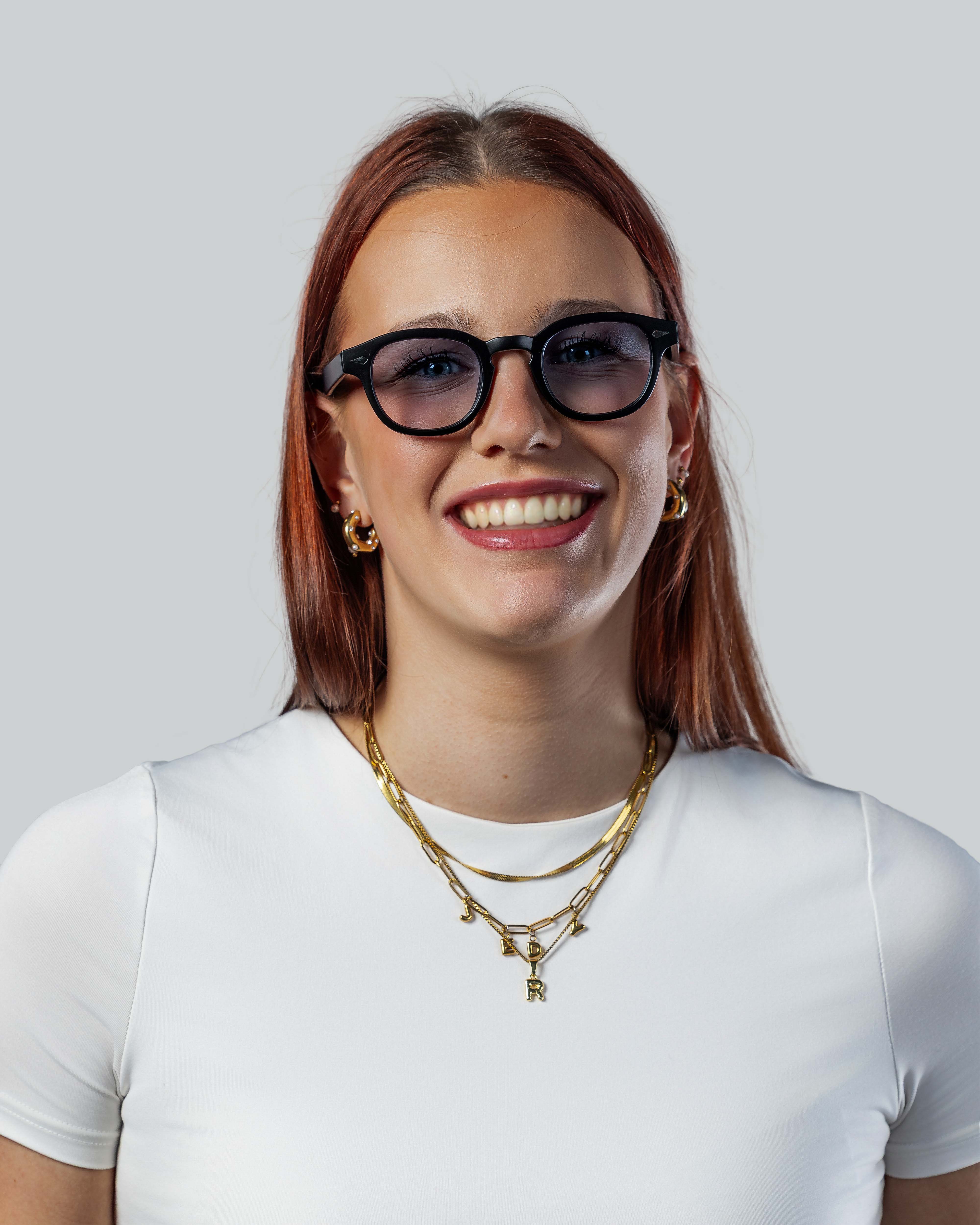 Vrouw met stijlvolle zonnebril en gouden sieraden, perfect voor een zonnige dag