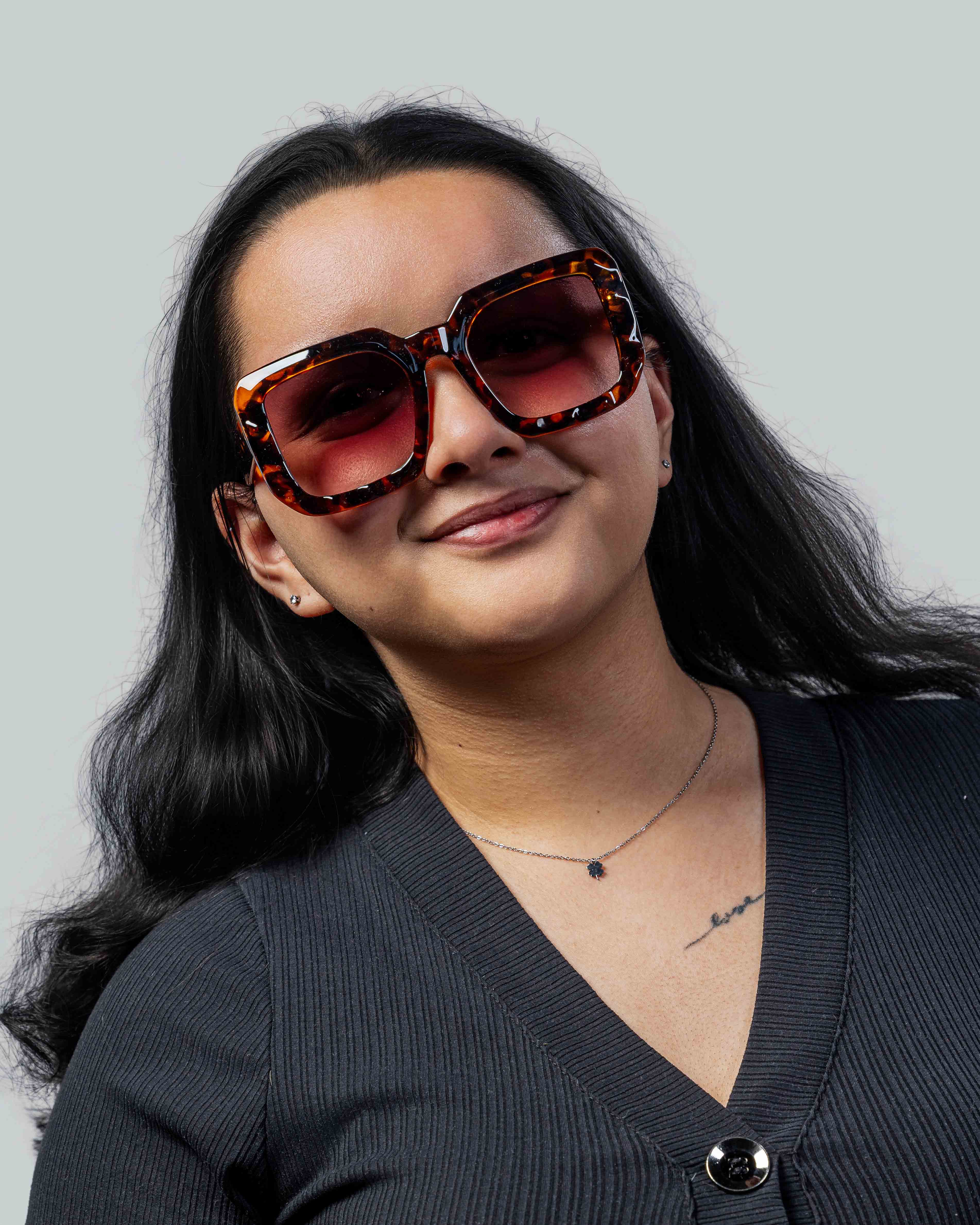 Vrouw met stijlvolle schildpadzonnebril en roze glazen, perfect voor een modieuze look.
