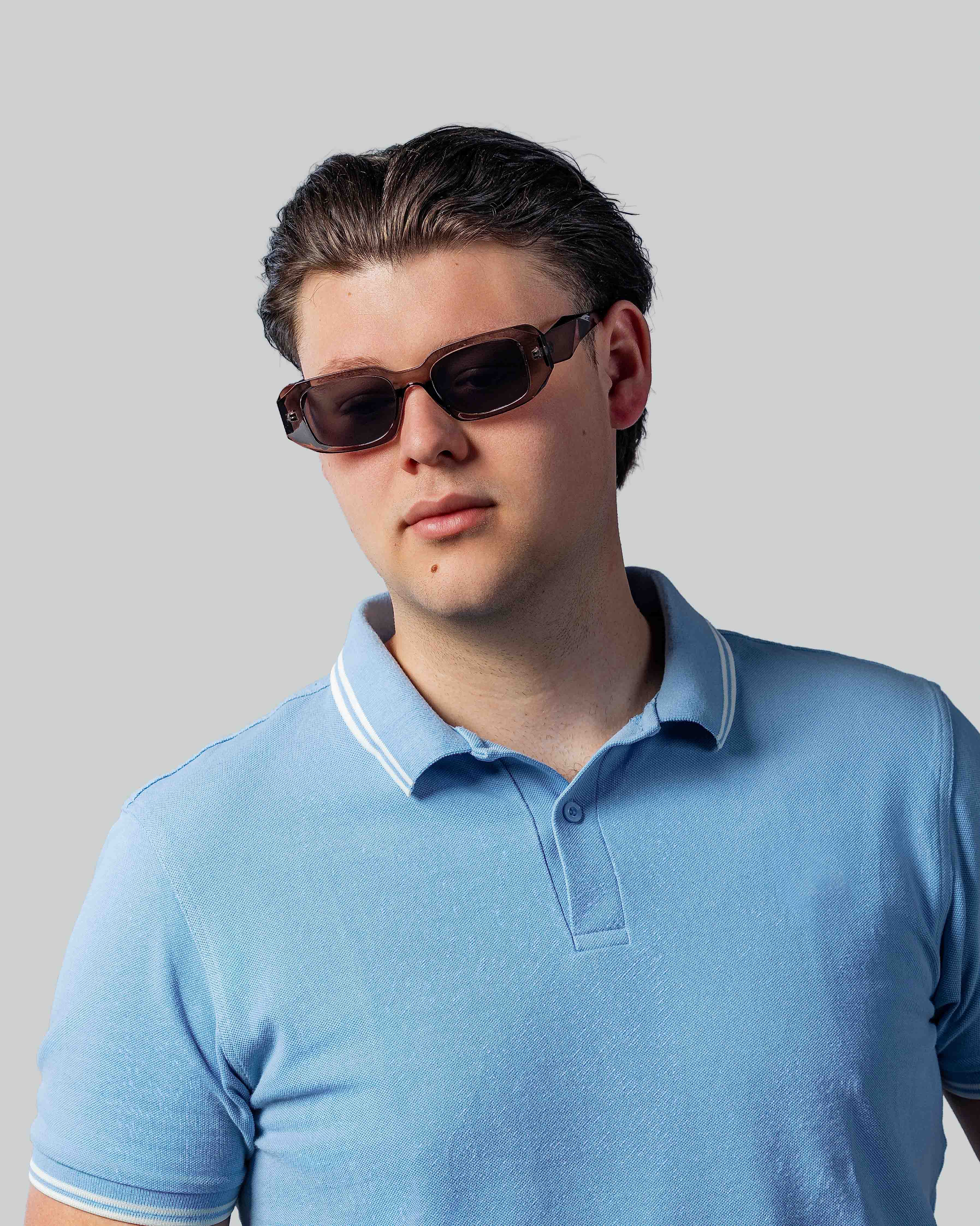 Stijlvolle zonnebril met rechthoekige montuur voor mannen, gedragen met lichtblauw poloshirt