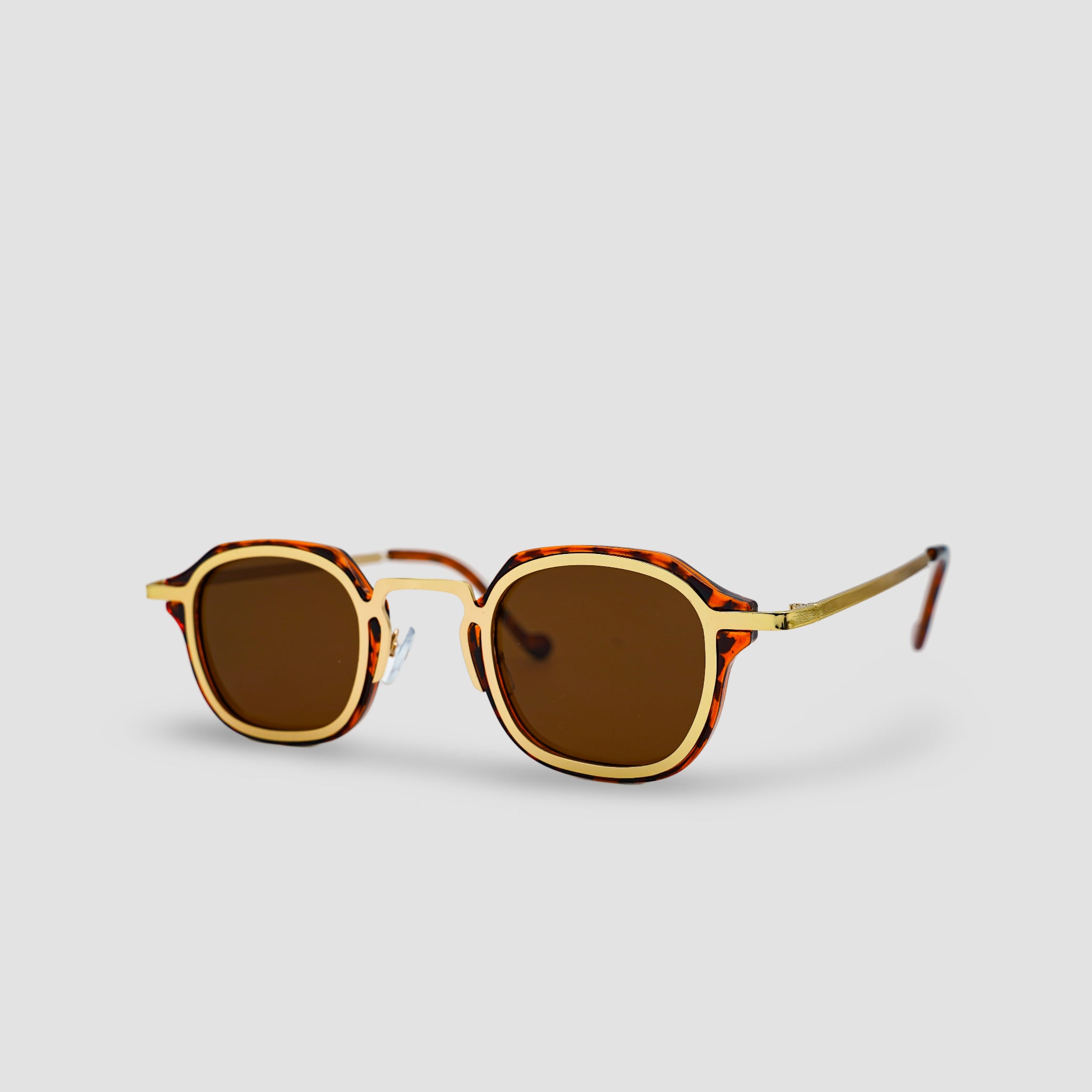 Stijlvolle zonnebril met schildpadpatroon en gouden montuur, perfect voor een trendy look.