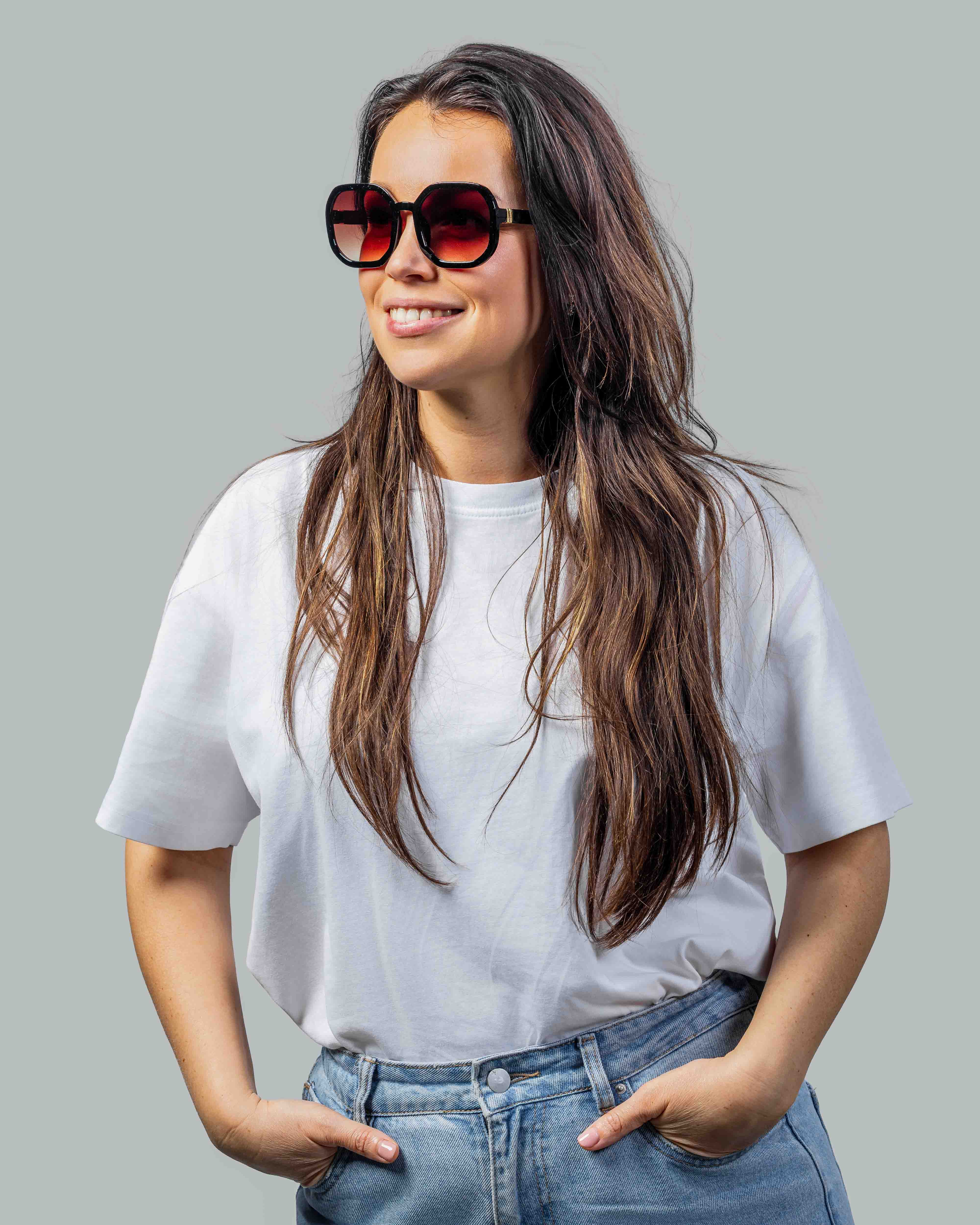 Vrouw met stijlvolle zonnebril, rode glazen en zwarte montuur, perfect voor zomerse dagen