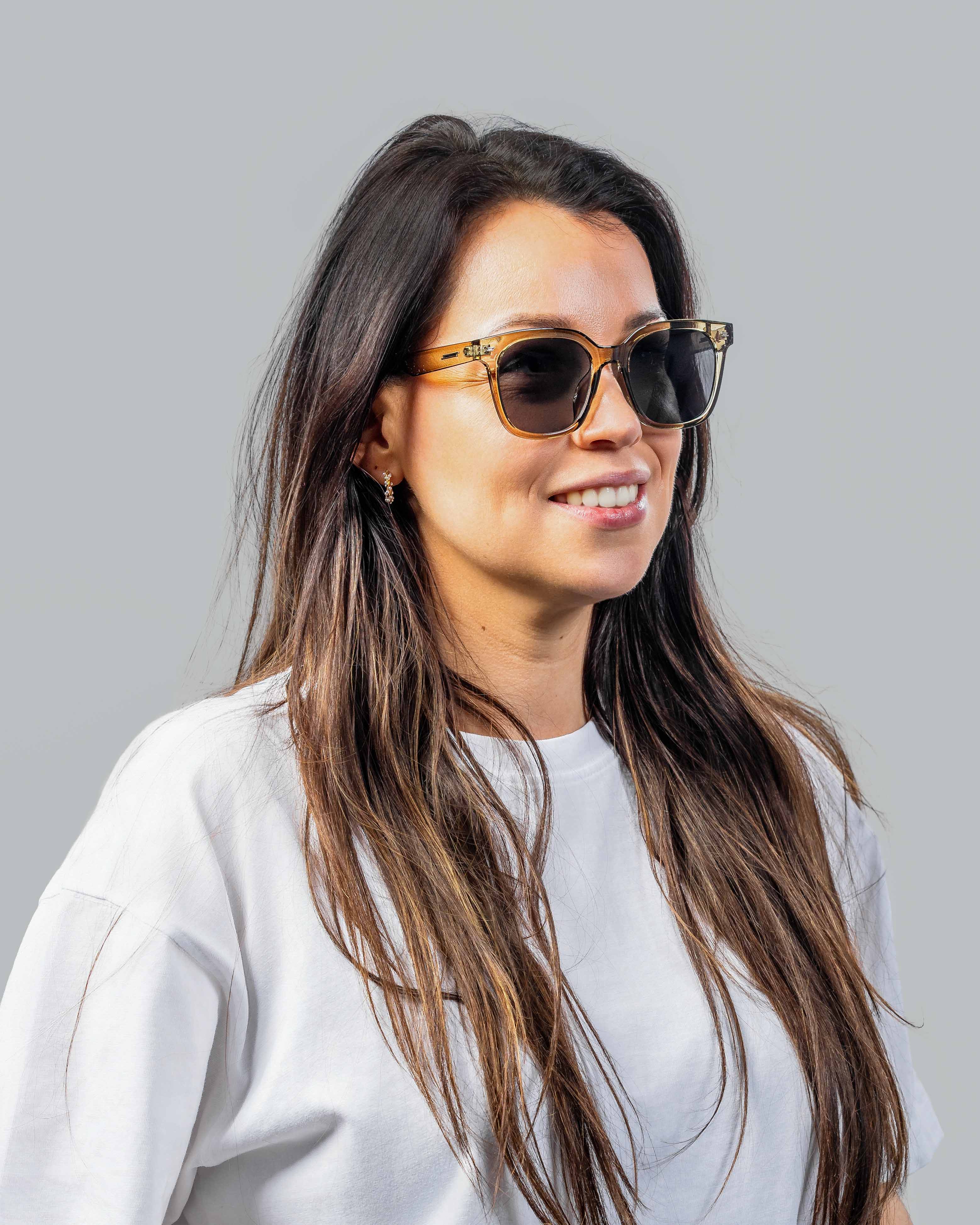 Vrouw met stijlvolle zonnebril, bruin montuur en donkere glazen, perfect voor zomerse dagen