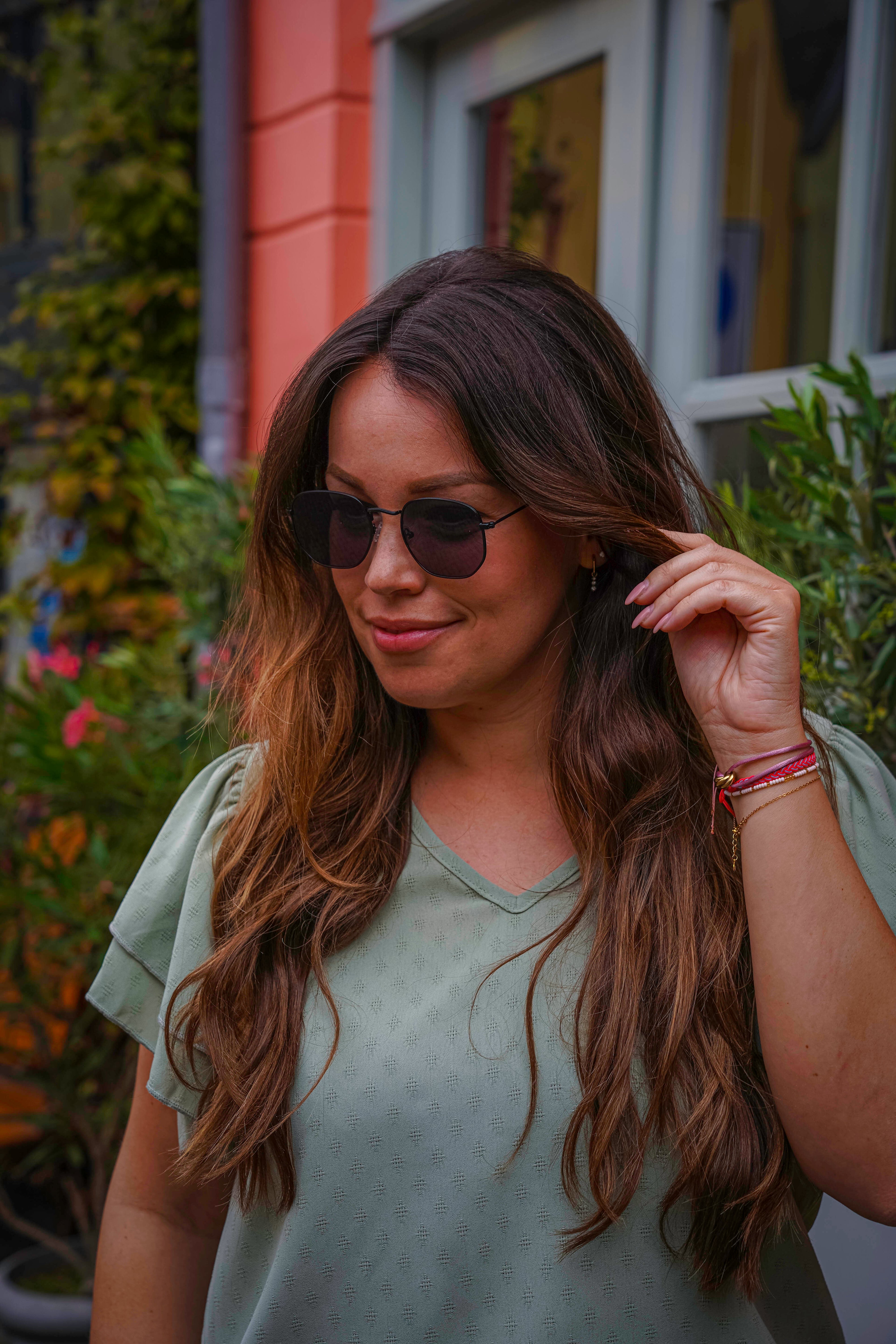 Vrouw met stijlvolle zonnebril en lang bruin haar, perfect voor zomerse dagen