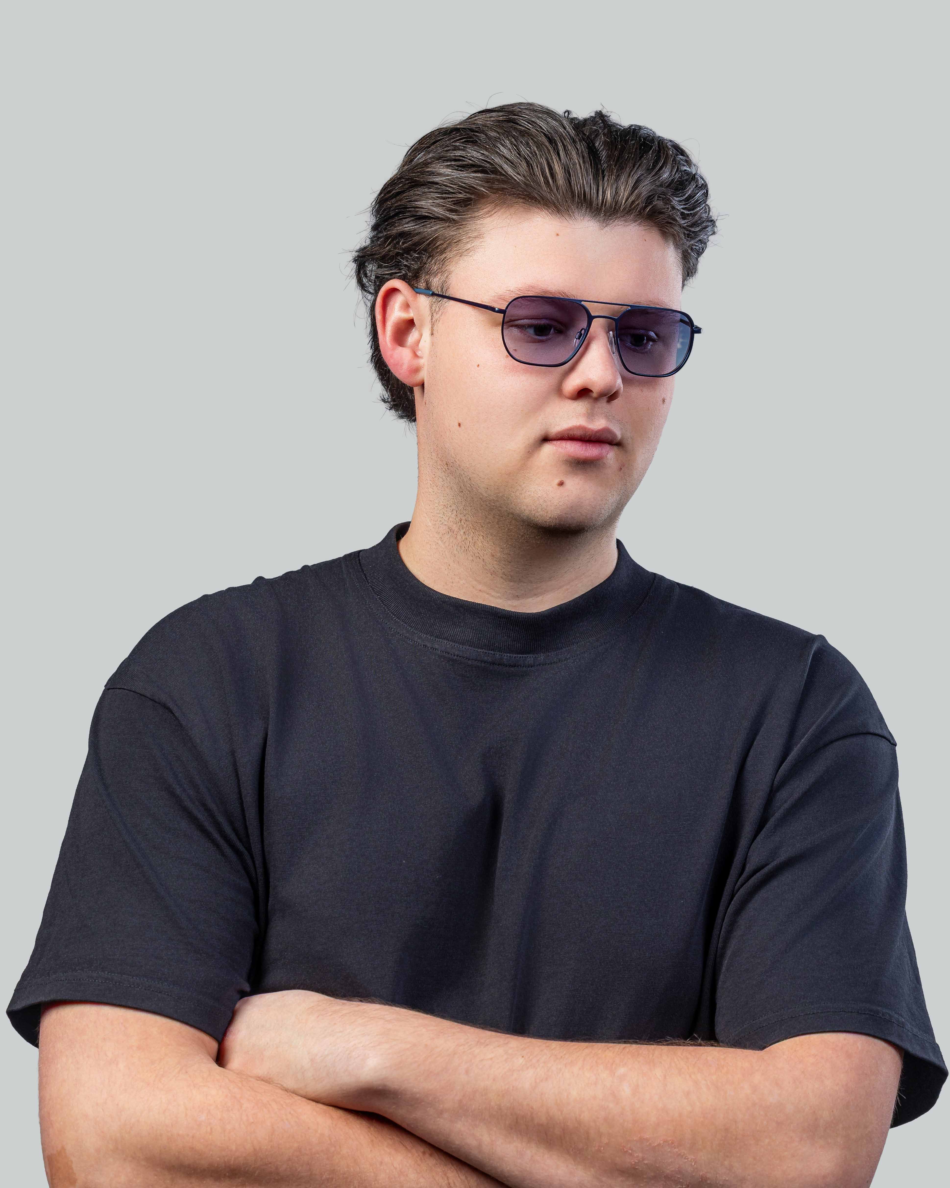 Man met stijlvolle zonnebril en donkere t-shirt, perfect voor een trendy look