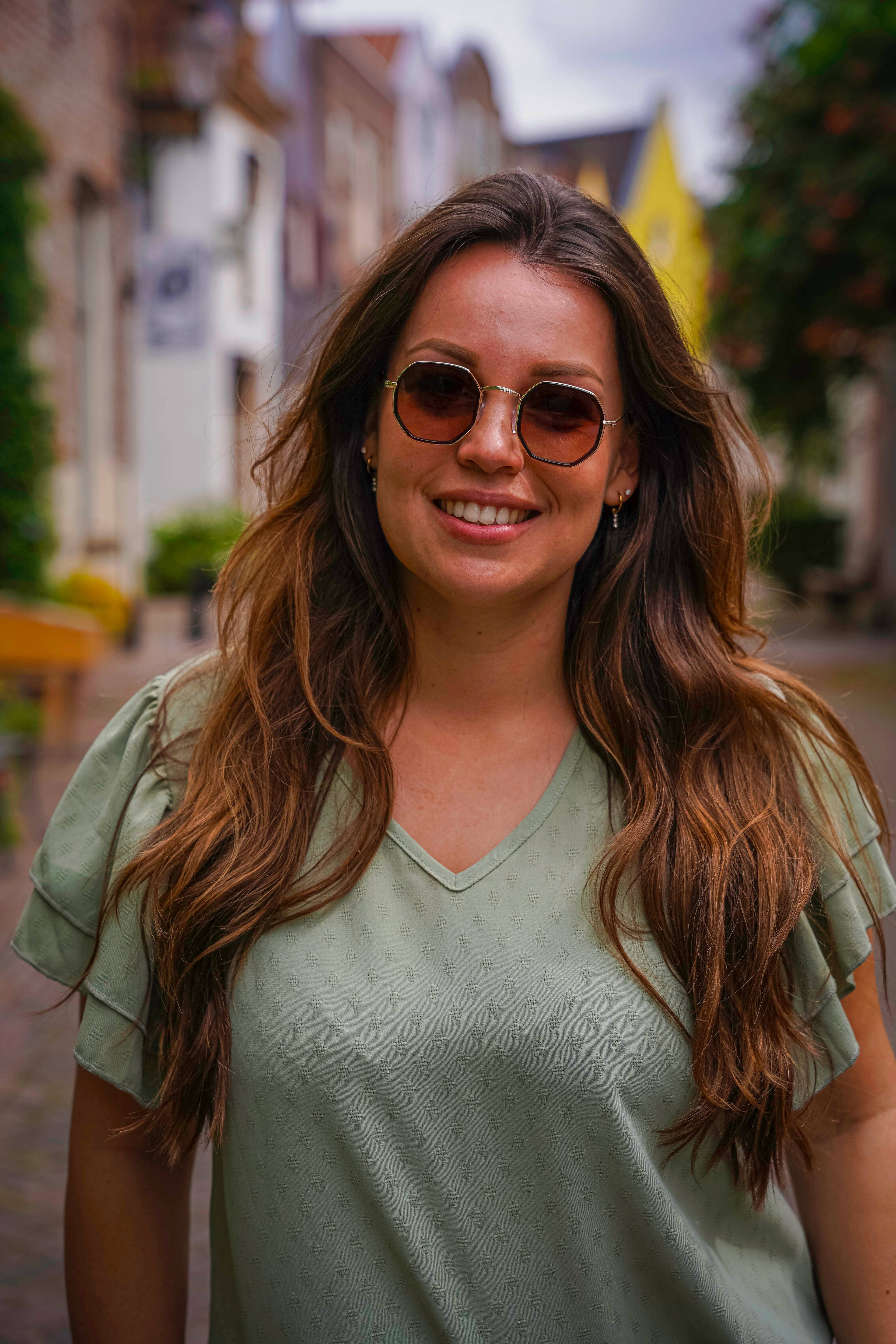 Vrouw met stijlvolle zonnebril in straat, perfecte zonnebril voor elke dag