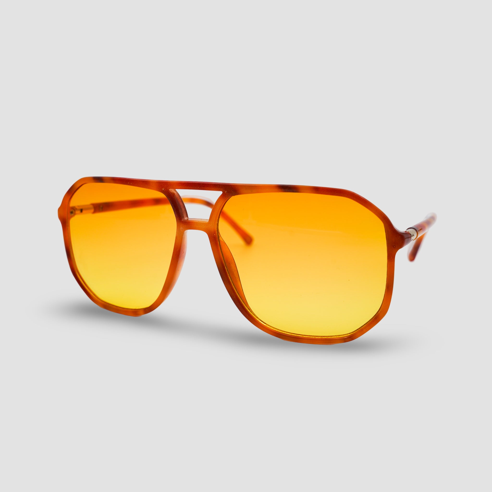 Stijlvolle zonnebril met amber glazen en tortoise frame, perfect voor zomerse dagen