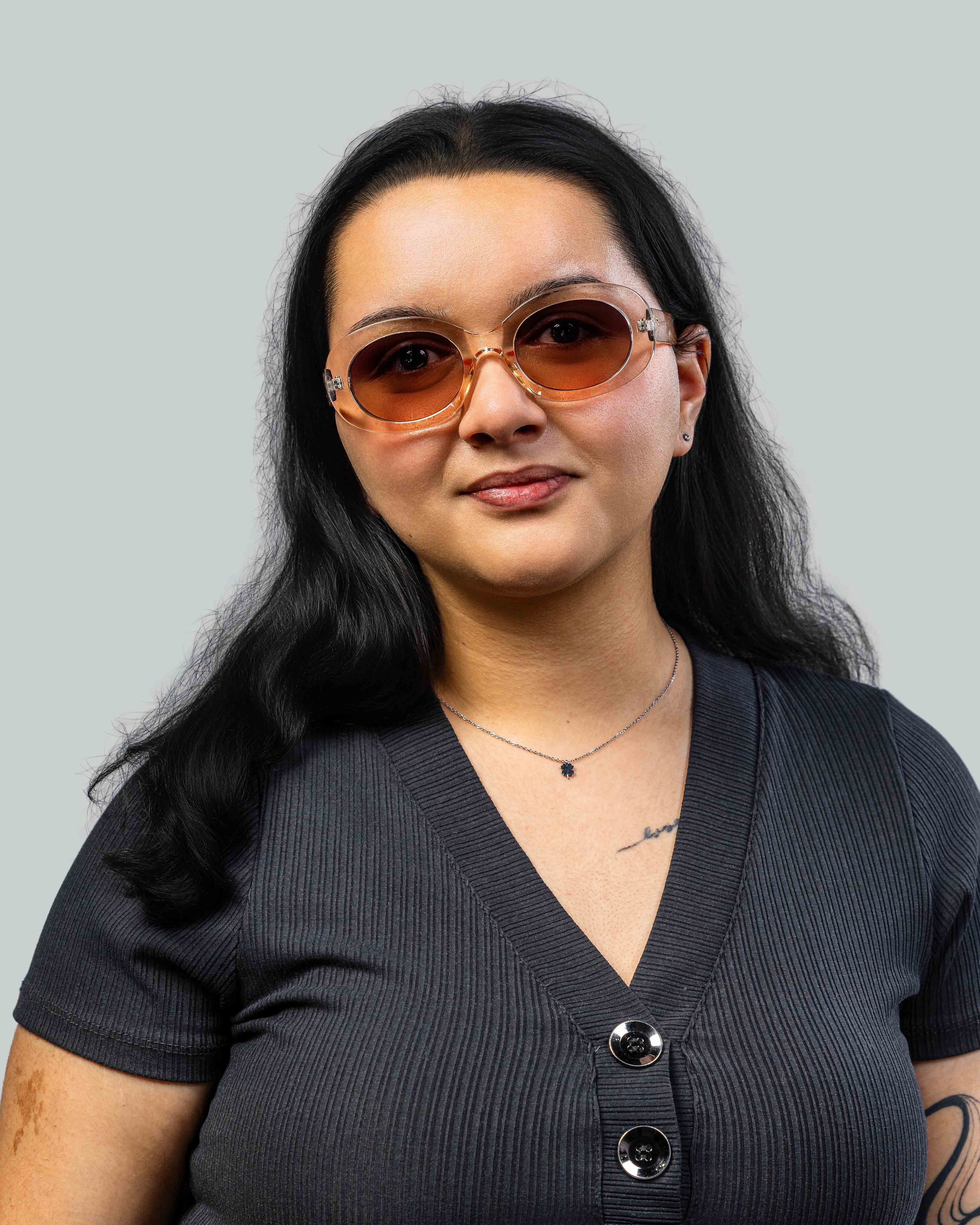 Vrouw met stijlvolle zonnebril, oranje glazen en transparante montuur, perfect voor zomerse looks