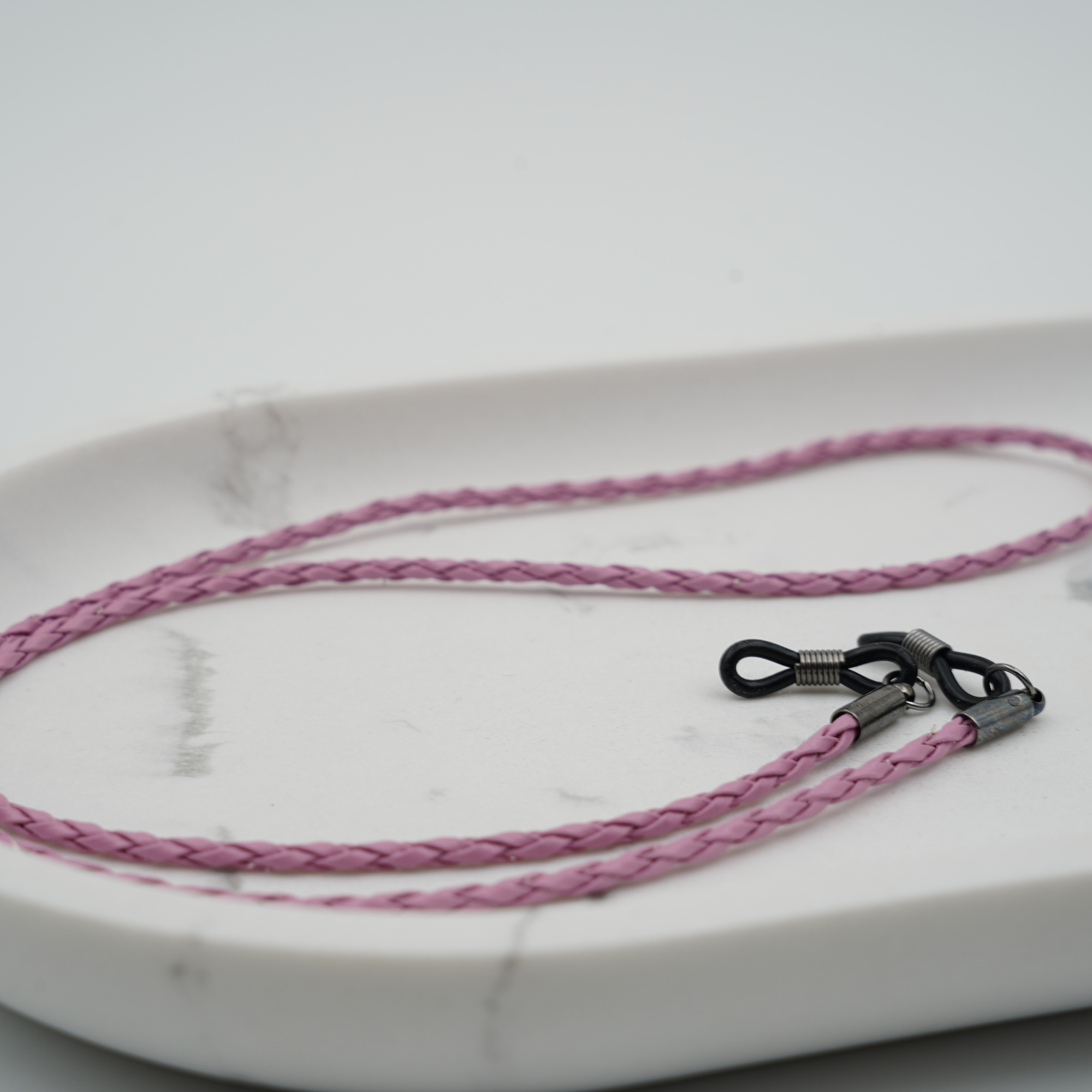 Roze gevlochten brillenkoord met zwart metalen clip, perfect voor zonnebrillen