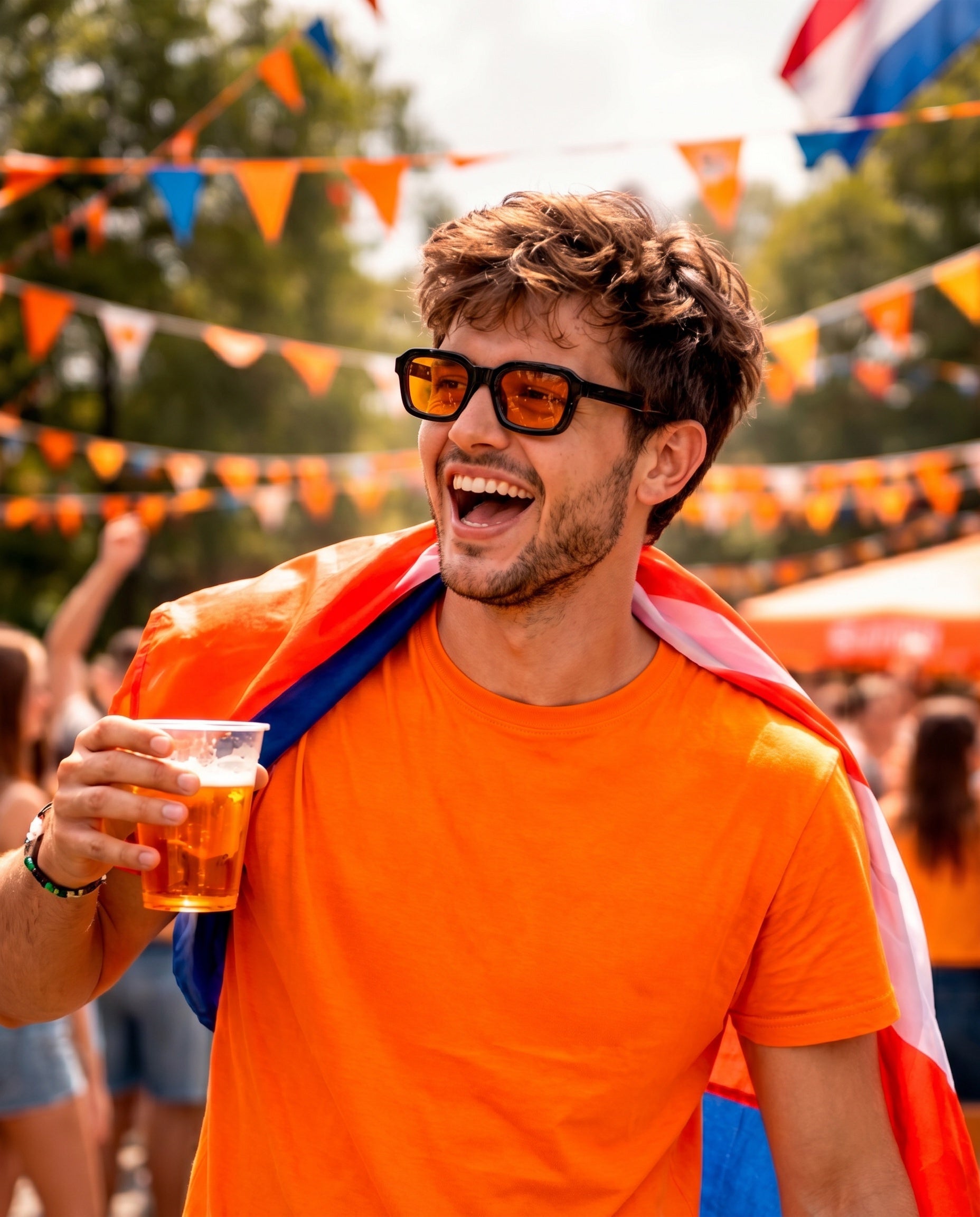 Man in oranje zonnebril en shirt met Nederlandse vlag, feestend met bier op festival