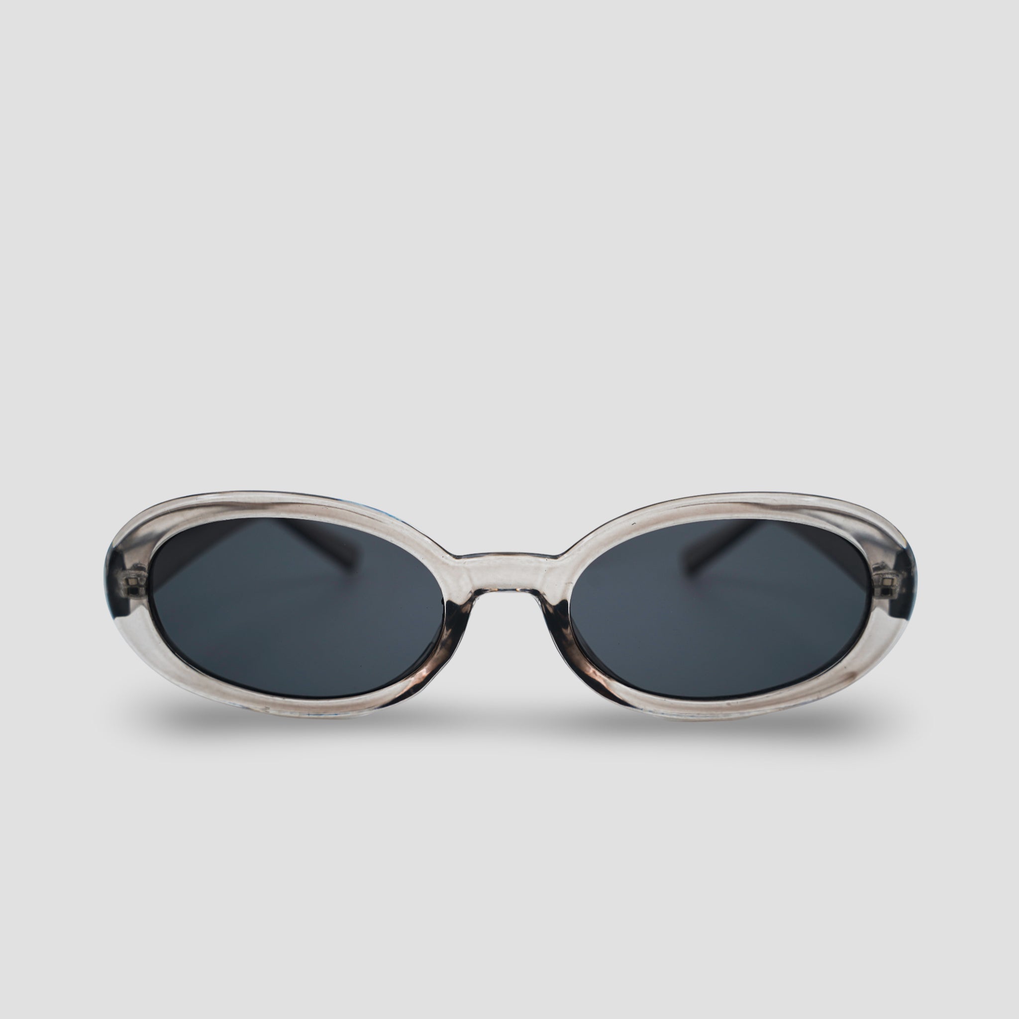 Stijlvolle ovale zonnebril met transparant montuur en donkere glazen, perfect voor een moderne look.