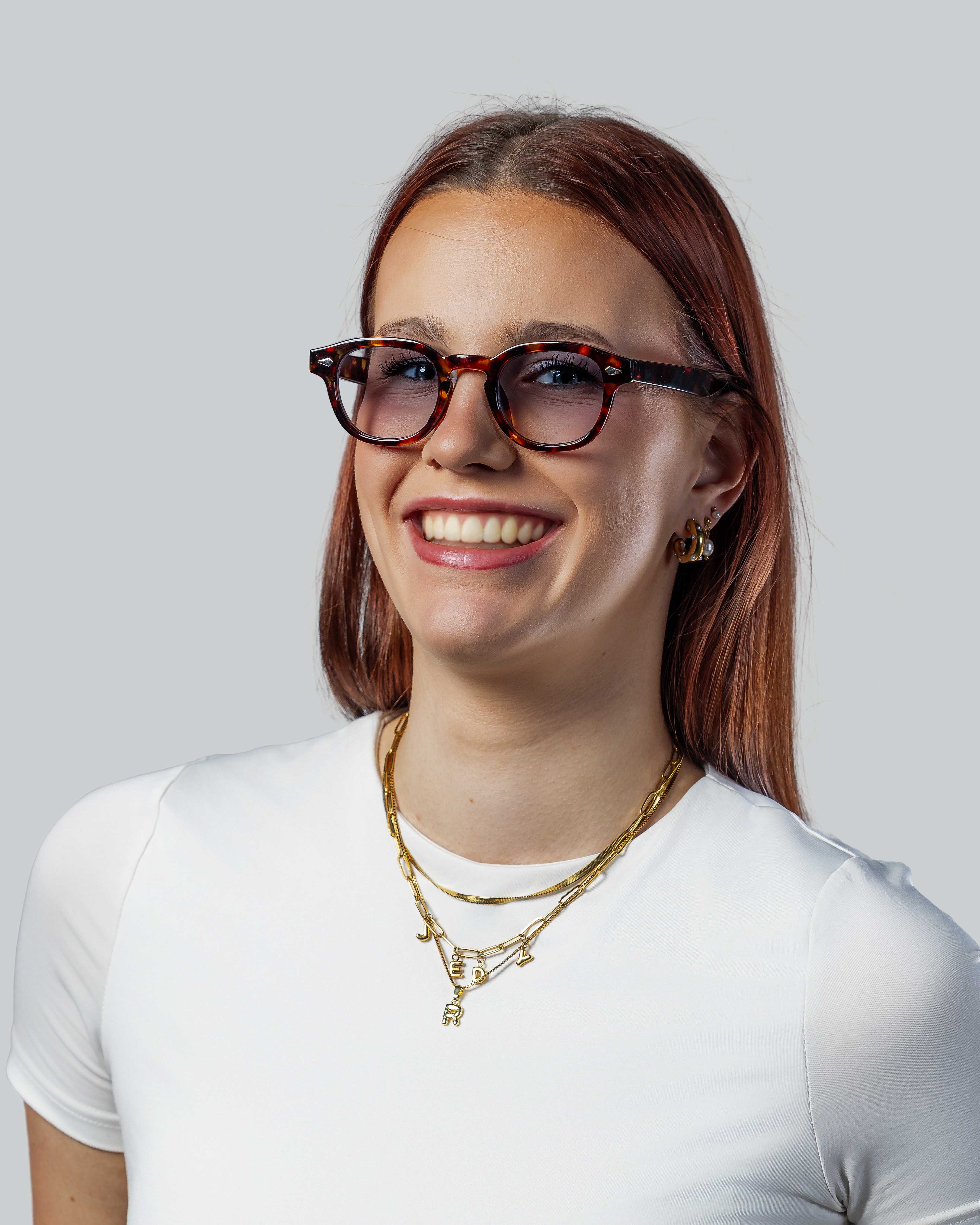 Vrouw met stijlvolle bruine zonnebril en gouden sieraden, perfect voor dagelijks gebruik