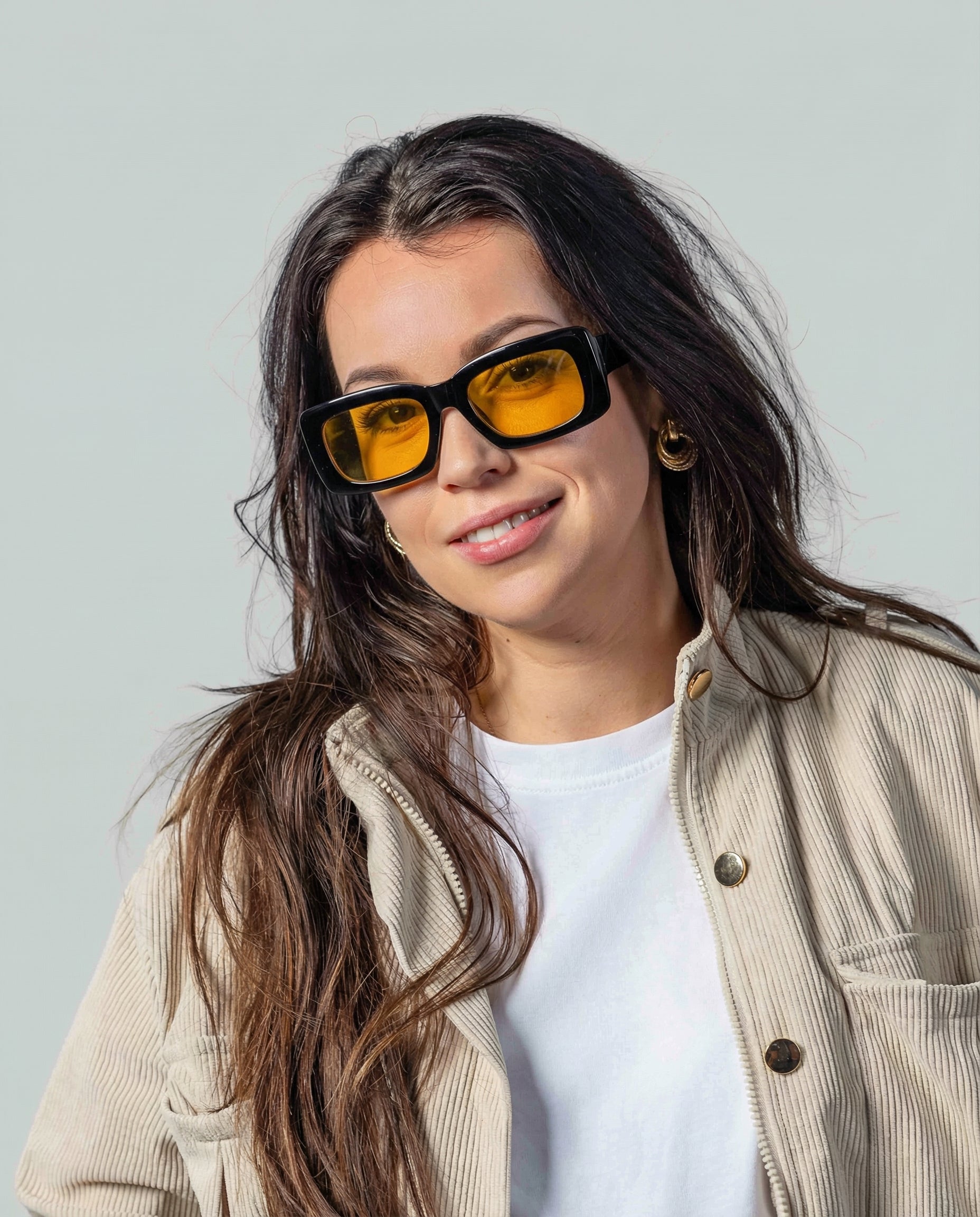 Vrouw met stijlvolle zonnebril met gele glazen en zwarte montuur, perfect voor een trendy look.