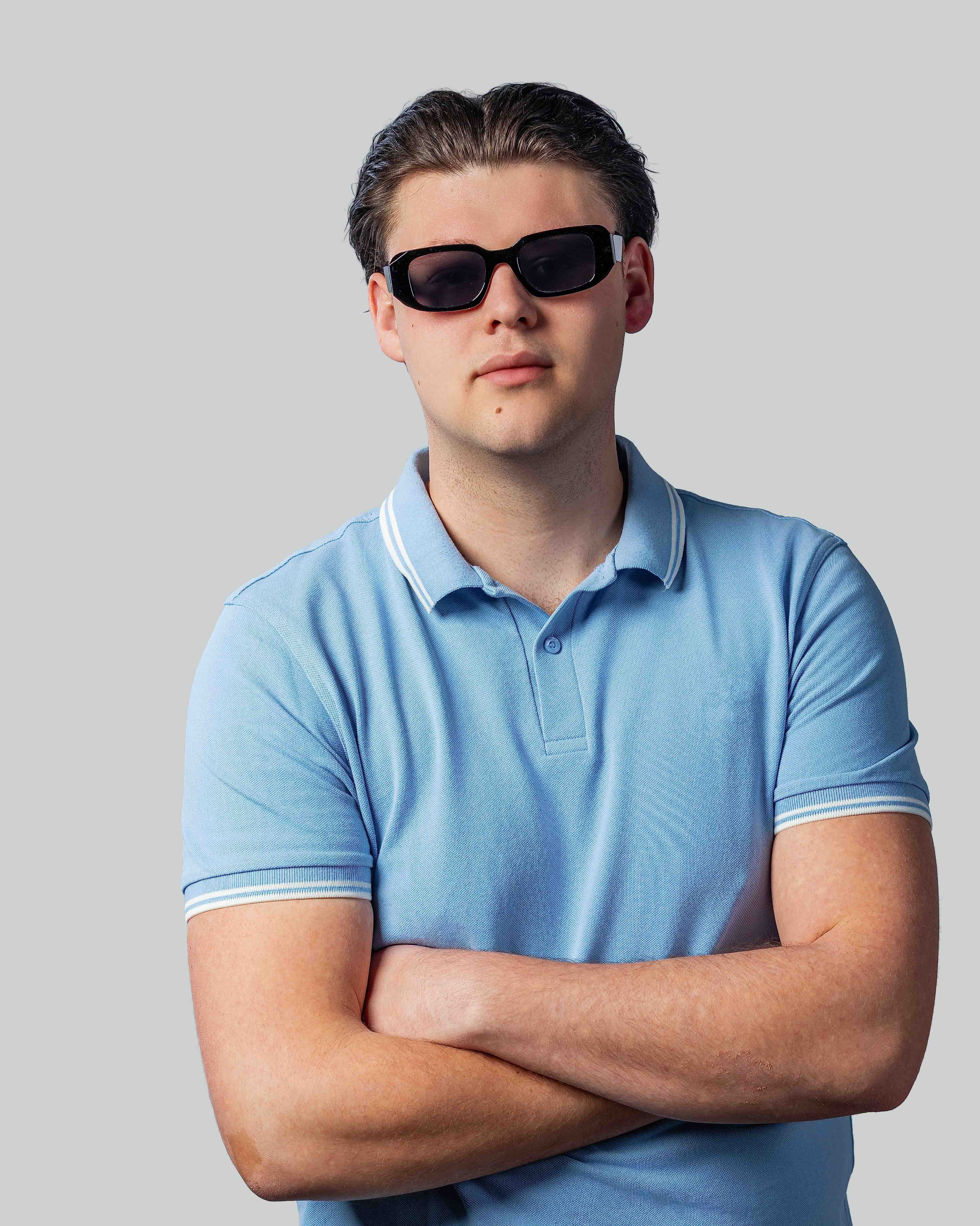Man met stijlvolle zonnebril en blauw poloshirt, perfect voor zonnige dagen