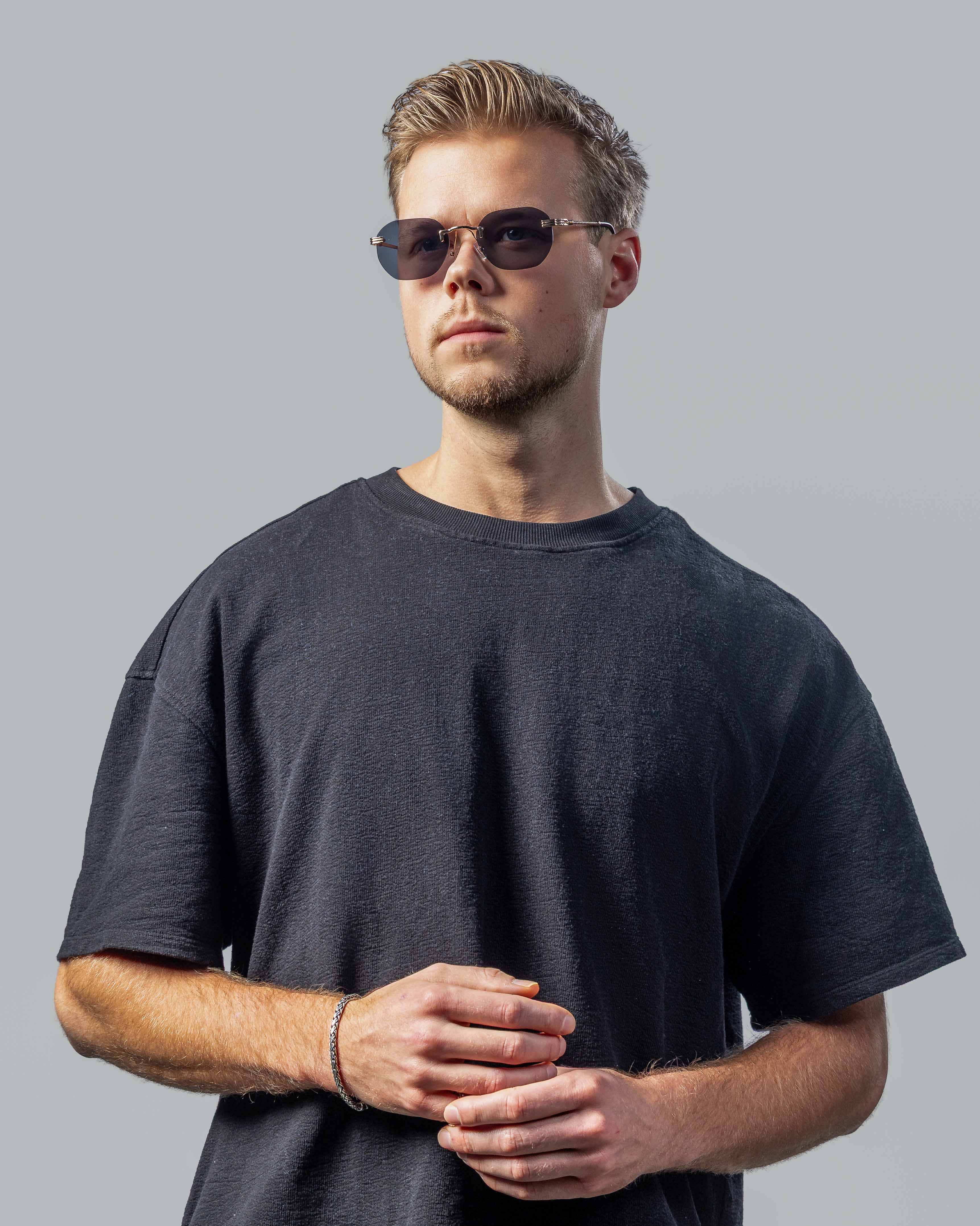 Man met stijlvolle zonnebril en donkere t-shirt, perfect voor een moderne look