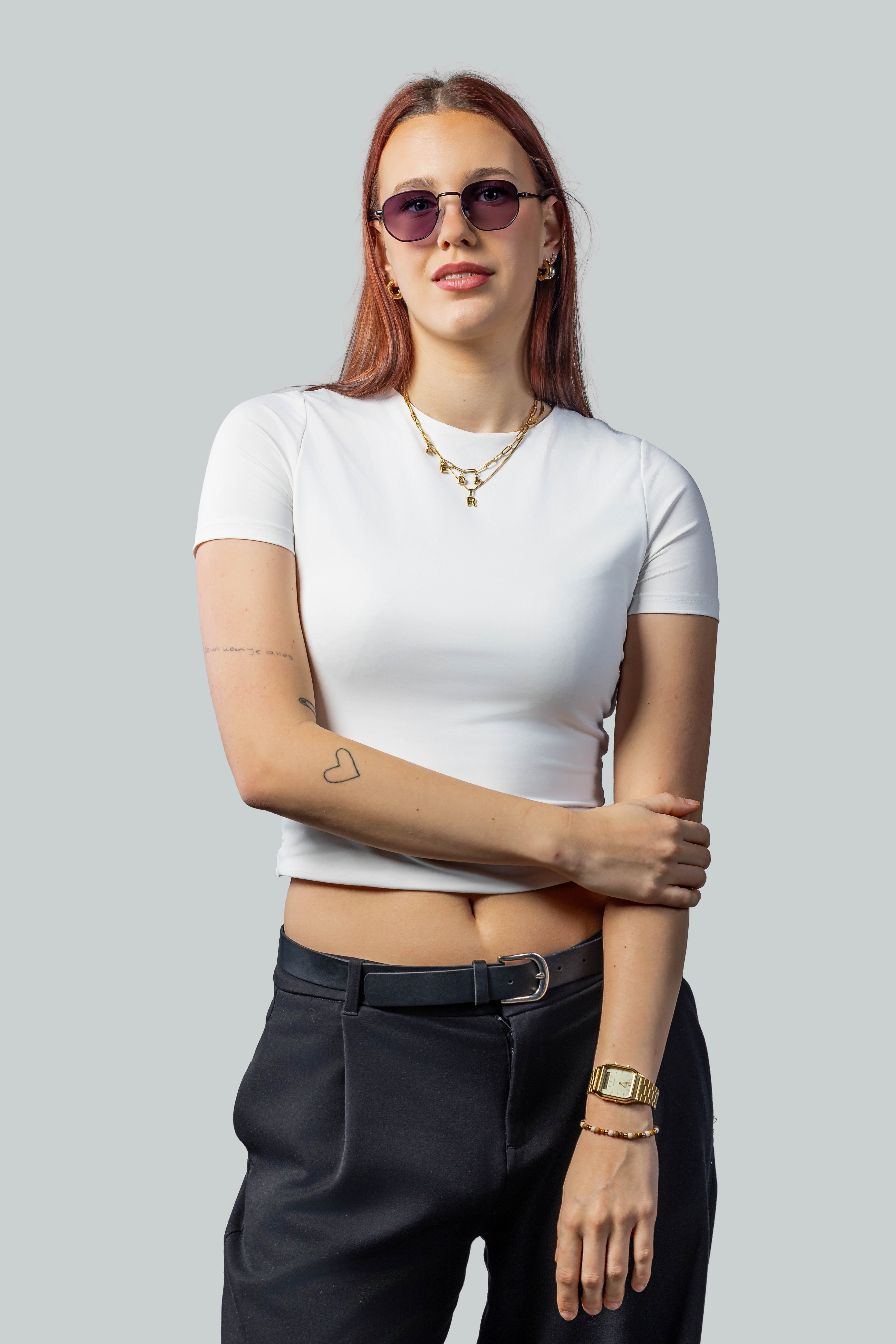 Vrouw met stijlvolle zonnebril, witte top en zwarte broek, perfect voor een modieuze look.