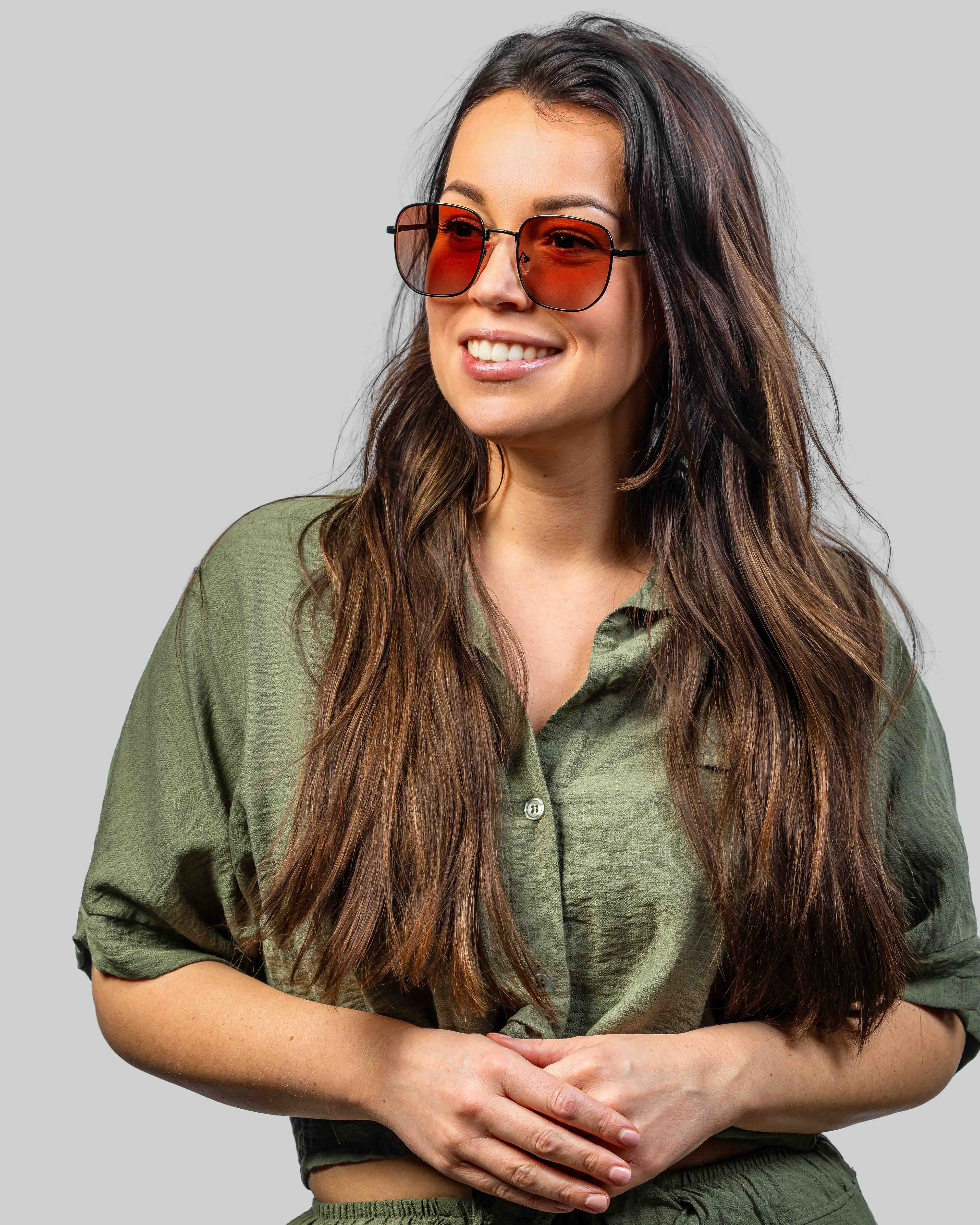 Vrouw met stijlvolle zonnebril met oranje glazen en zwarte montuur, perfect voor zomerse dagen.