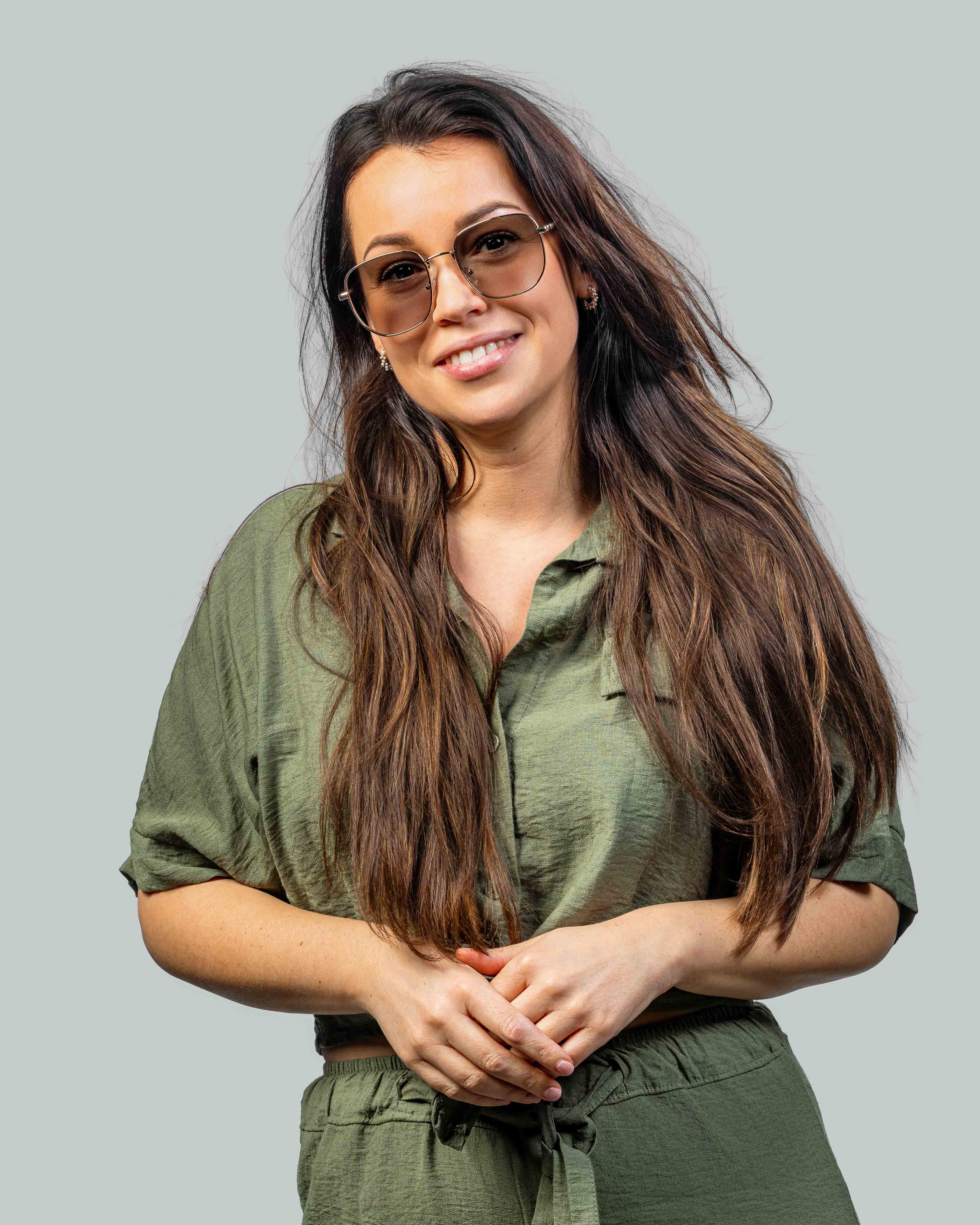 Vrouw met stijlvolle zonnebril en groene outfit, perfect voor een zonnige dag