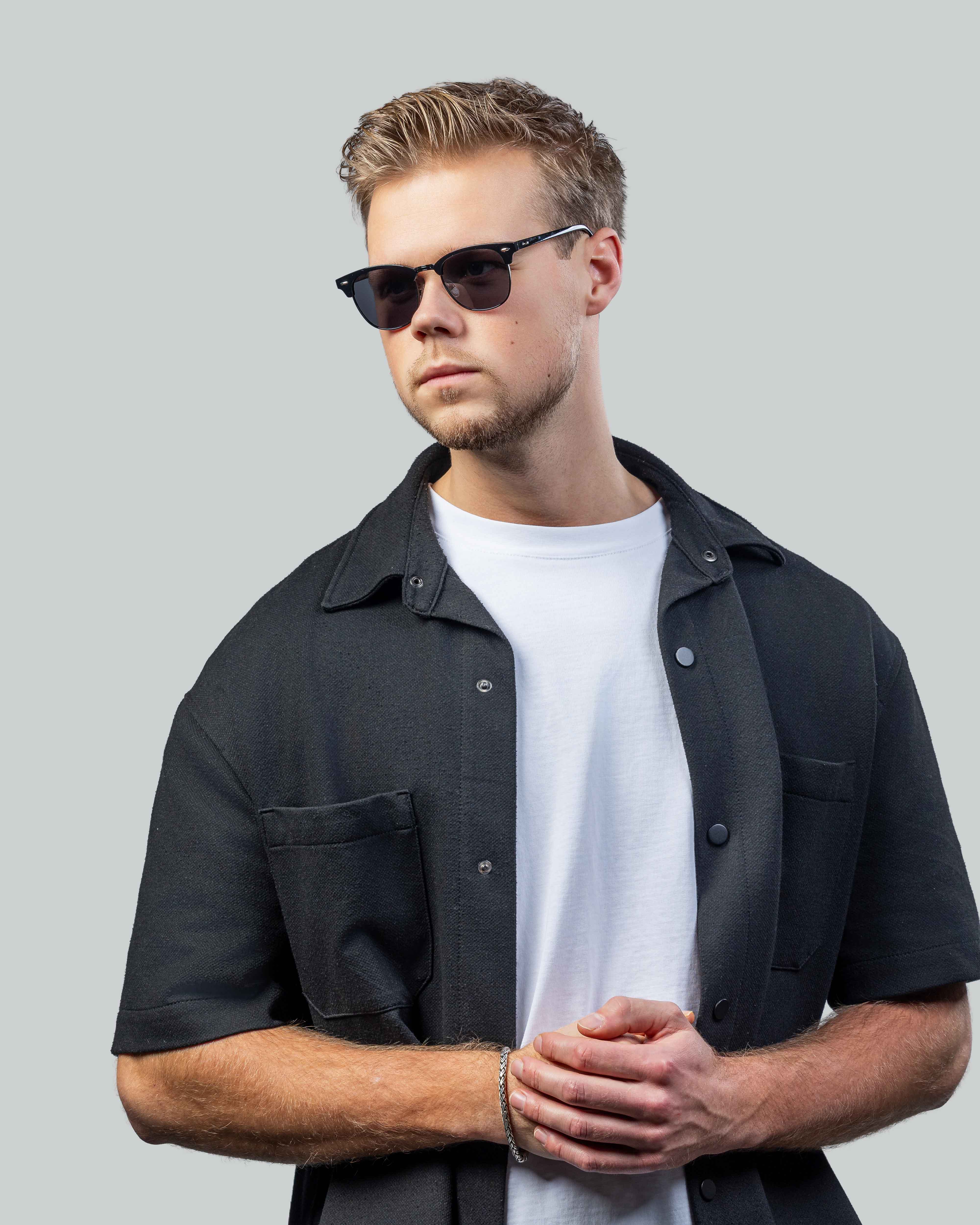 Stijlvolle zonnebril voor mannen, perfect voor een moderne look met zwarte bril en donkere kleding