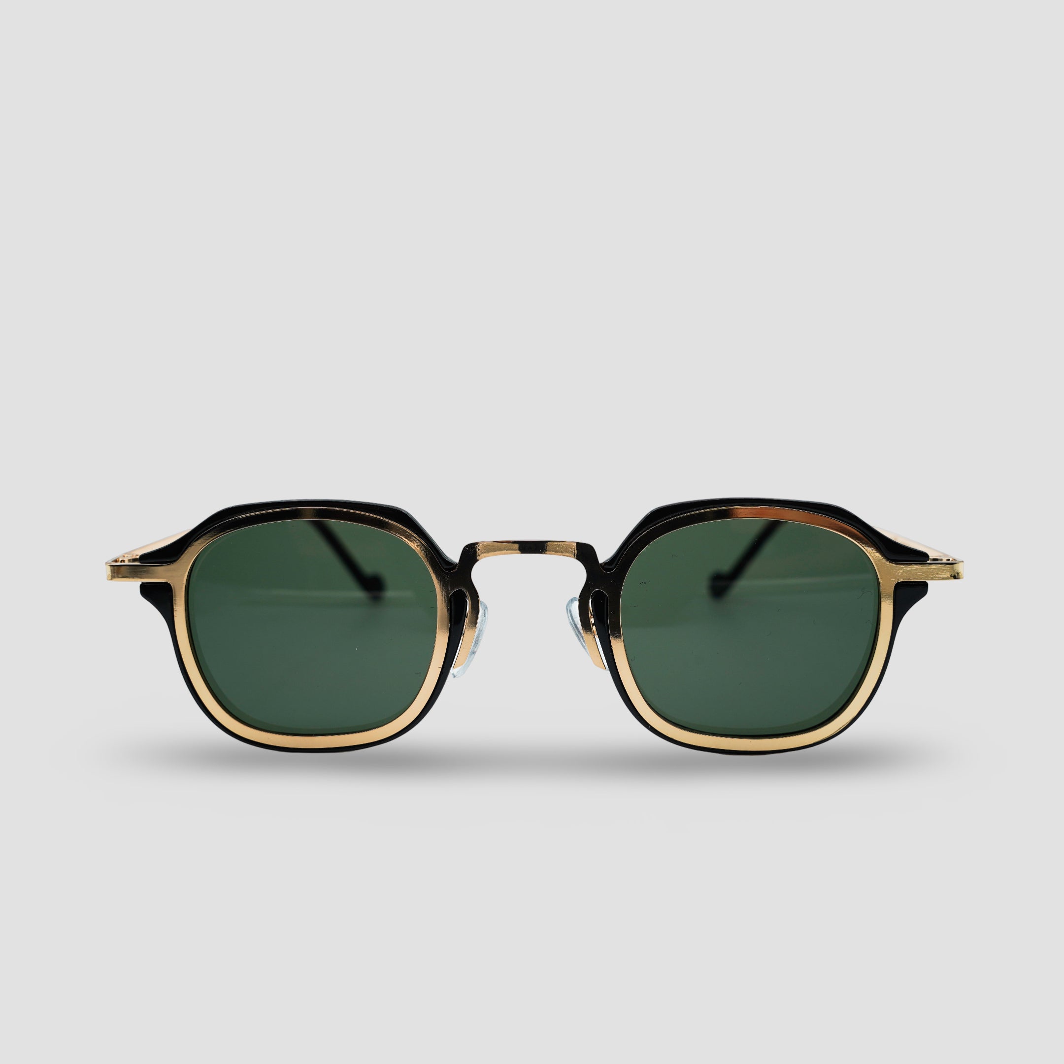 Stijlvolle zonnebril met goudkleurige montuur en groene glazen, perfect voor een trendy look.
