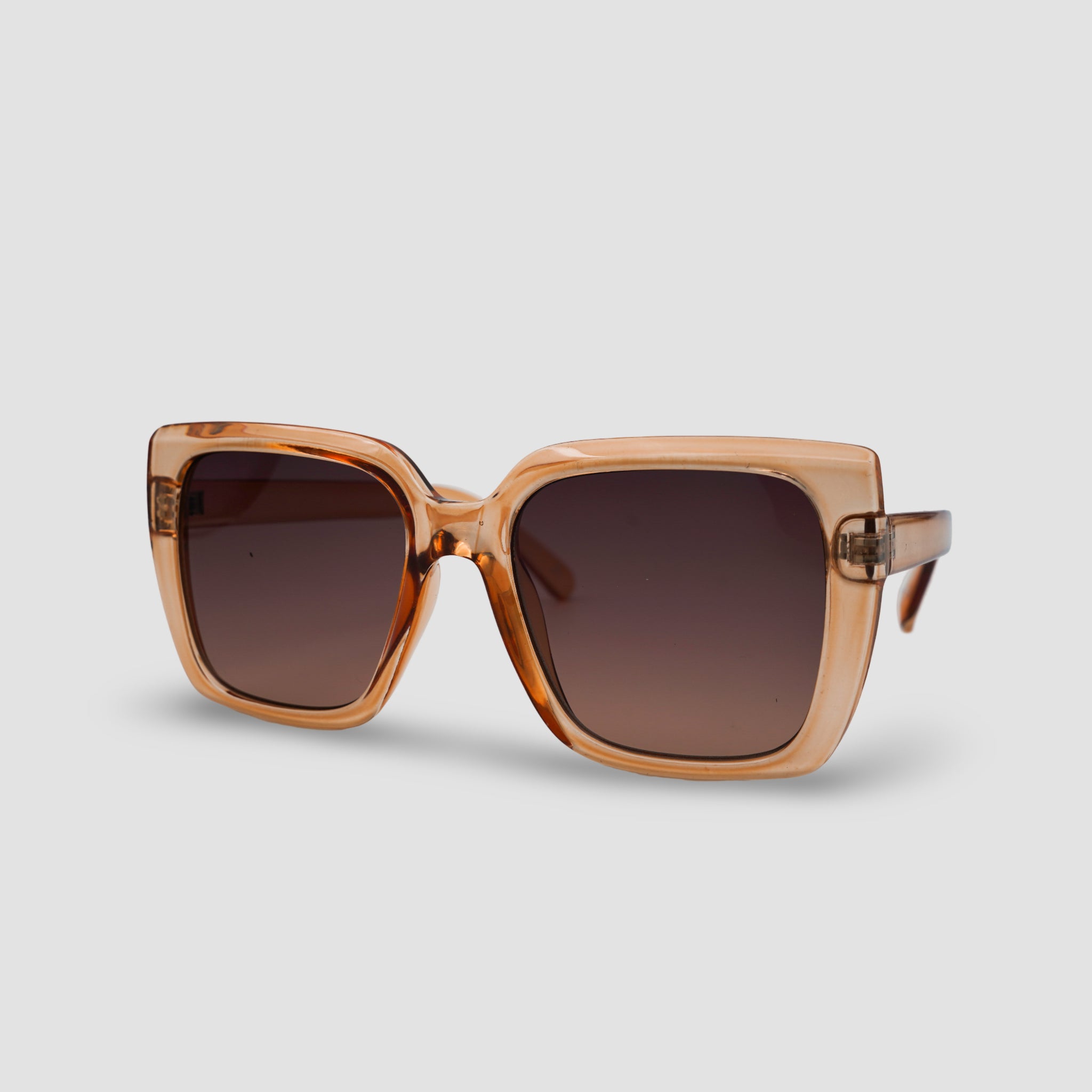 Stijlvolle vierkante zonnebril met bruine glazen en transparant montuur, perfect voor een trendy look.