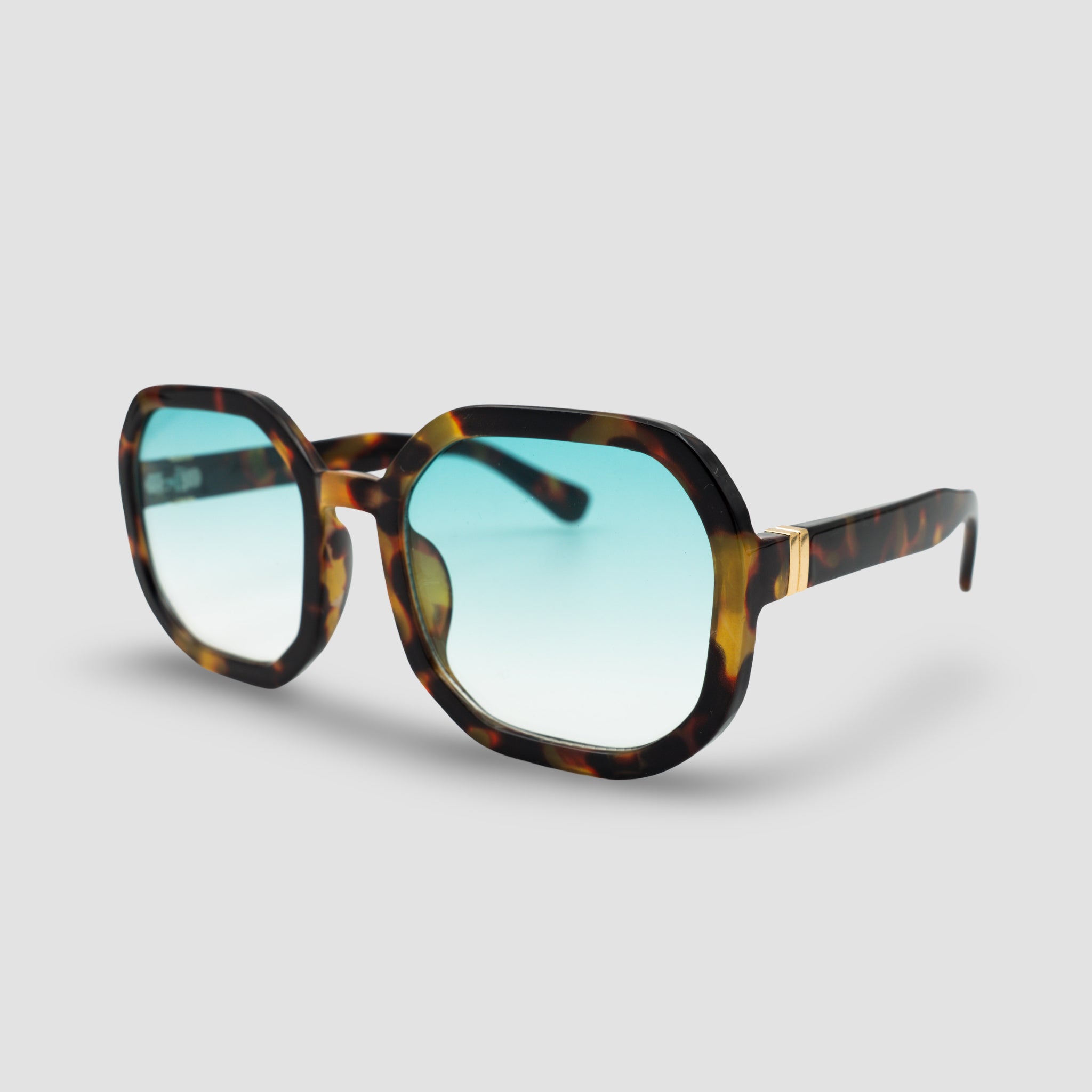 Stijlvolle zonnebril met schildpadpatroon en blauwe glazen, perfect voor een trendy look.