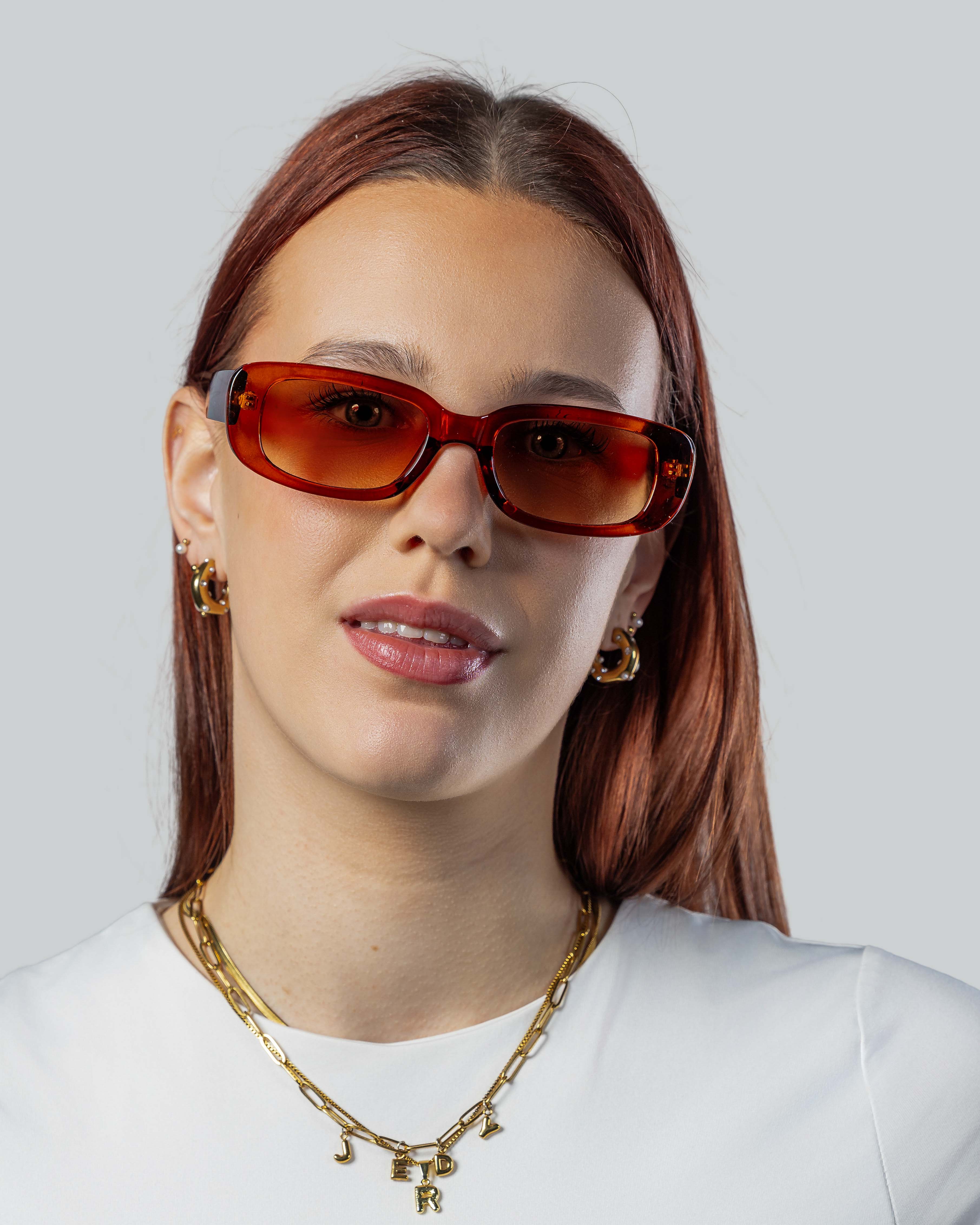Vrouw met stijlvolle amberkleurige zonnebril, perfect voor een trendy look