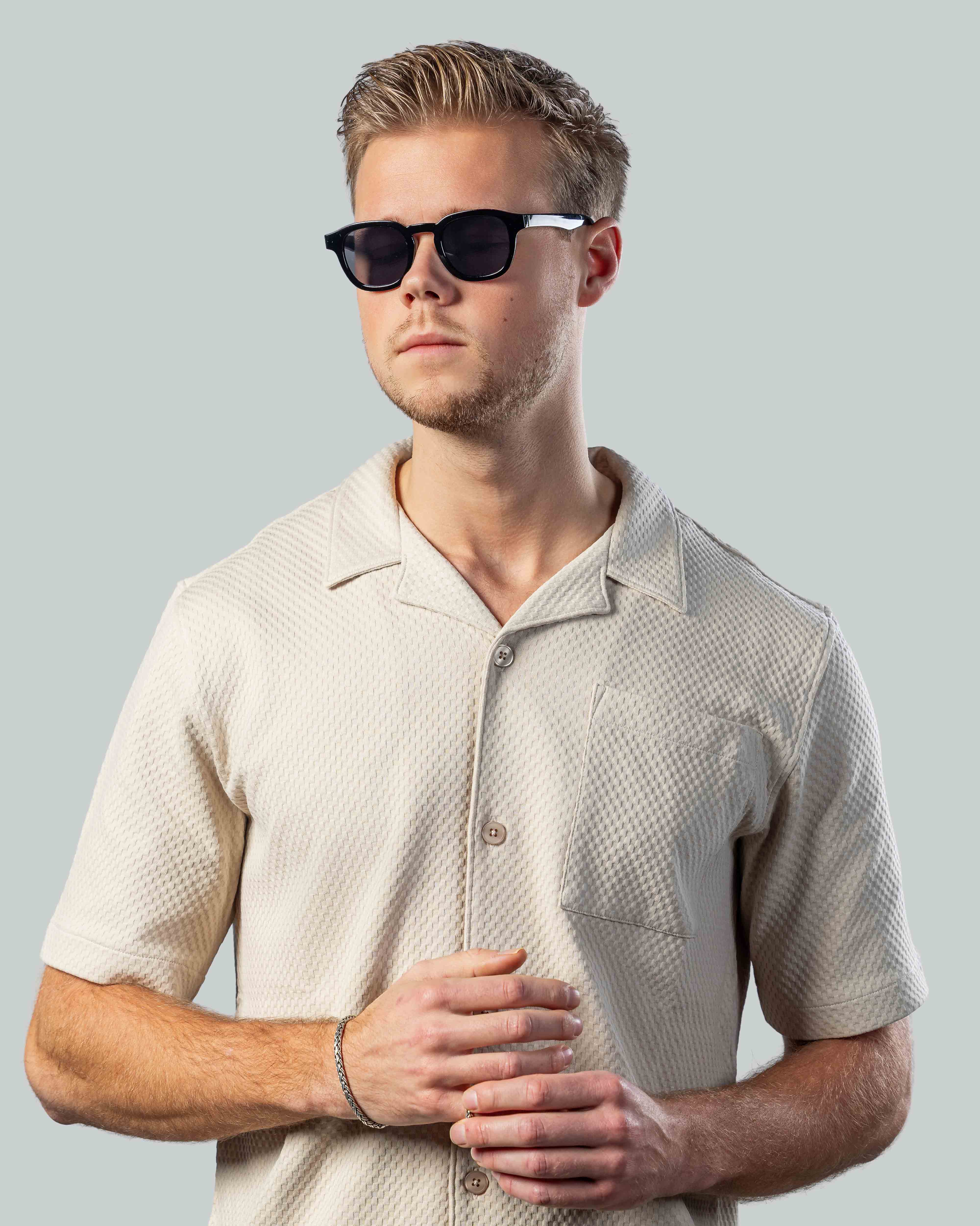 Stijlvolle zonnebril voor mannen, perfect voor een moderne look met een lichte shirt.