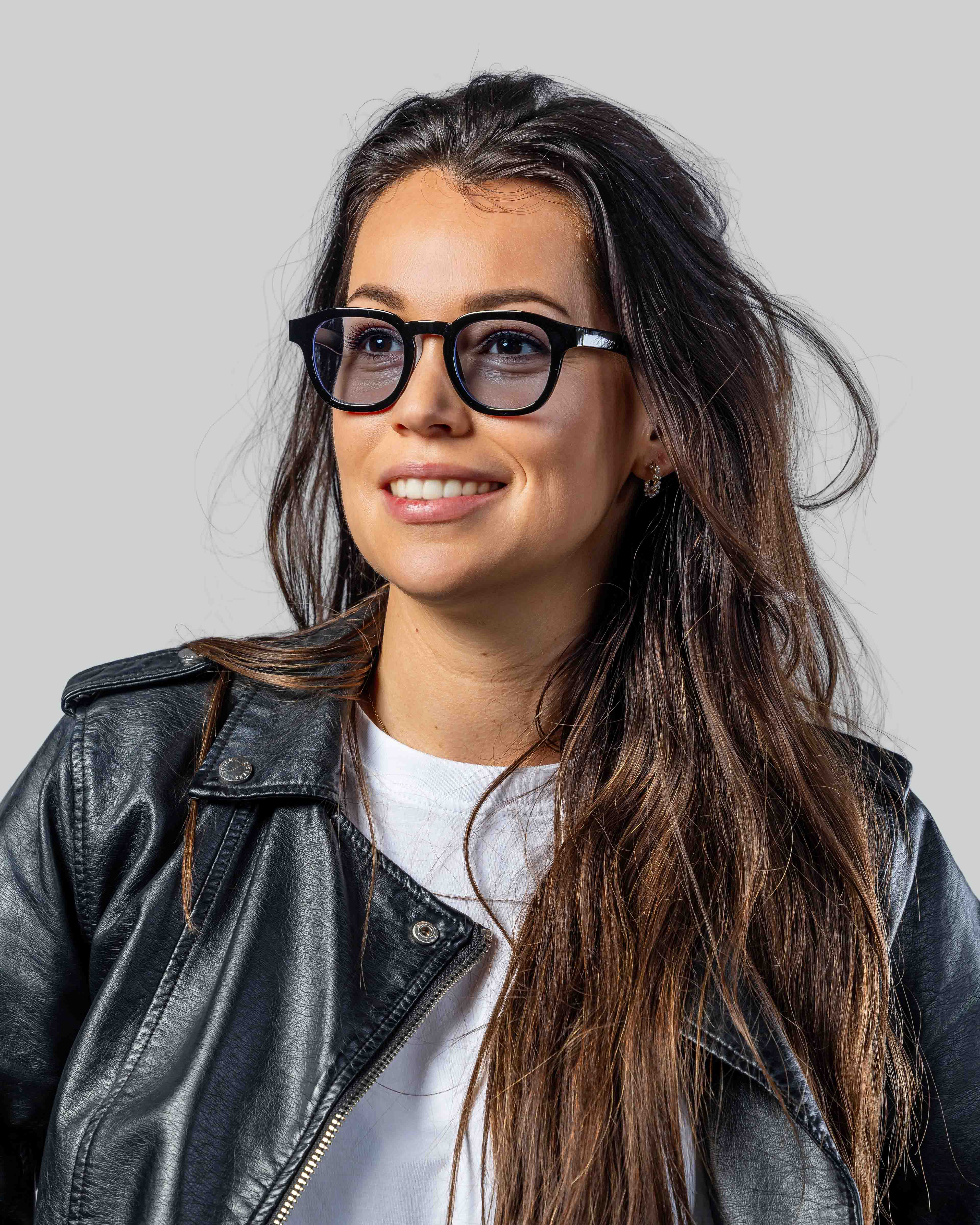 Vrouw met stijlvolle zwarte zonnebril en lederen jas, perfect voor een trendy look