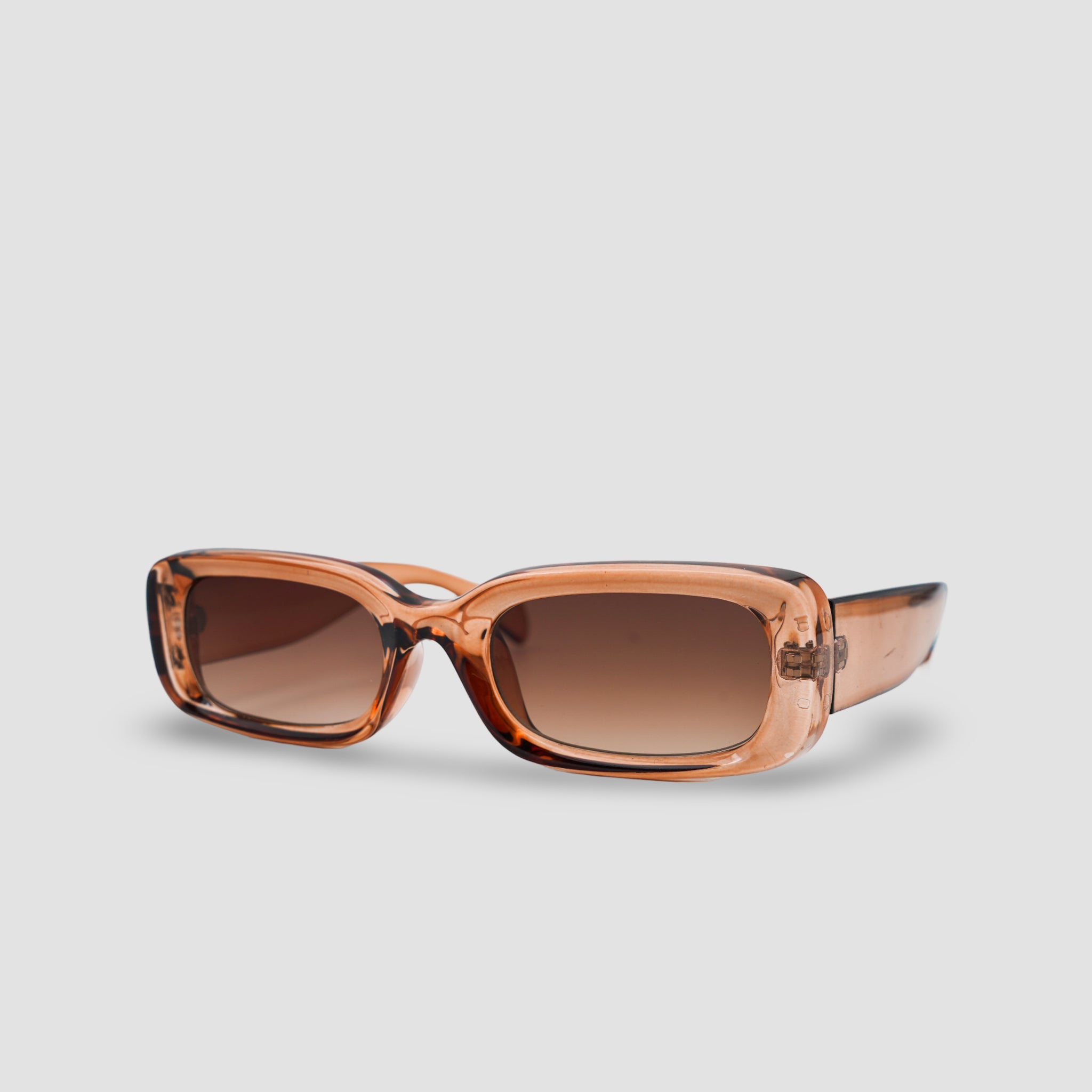 Stijlvolle rechthoekige zonnebril met bruine glazen en transparant montuur, perfect voor een modieuze look.