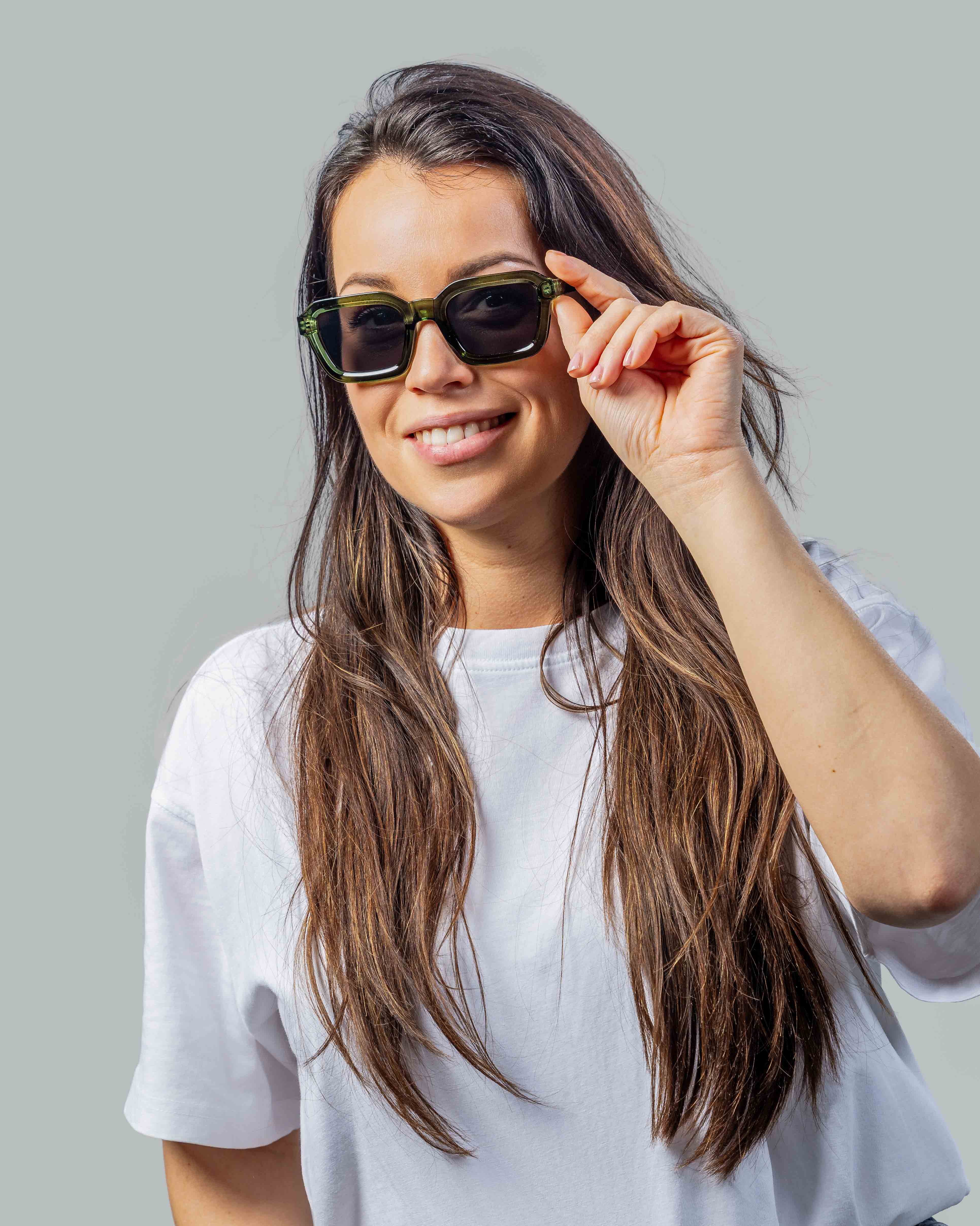 Vrouw met stijlvolle groene zonnebril en witte t-shirt, perfect voor zonnige dagen