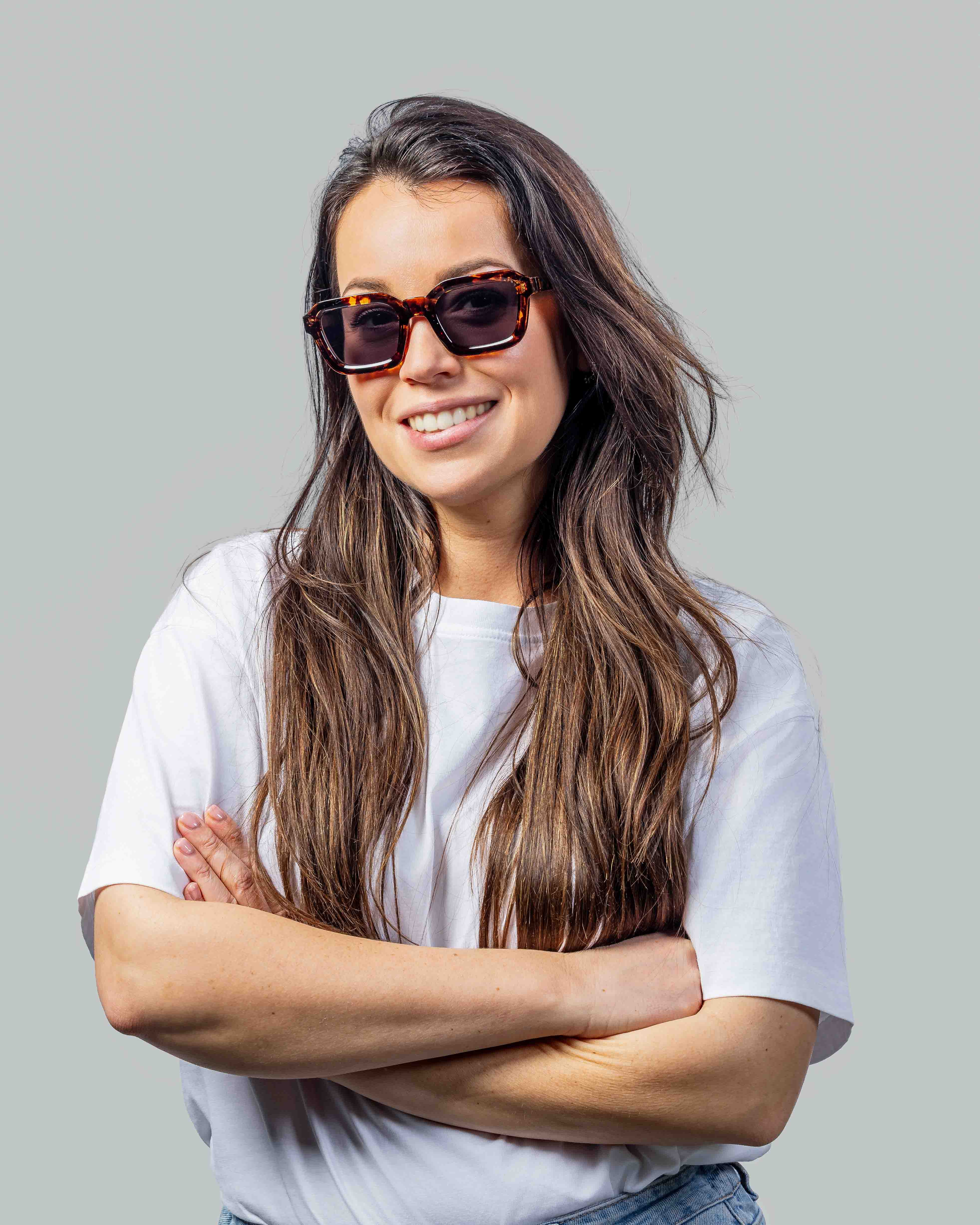 Vrouw met stijlvolle zonnebril en wit T-shirt, perfect voor zomerse dagen