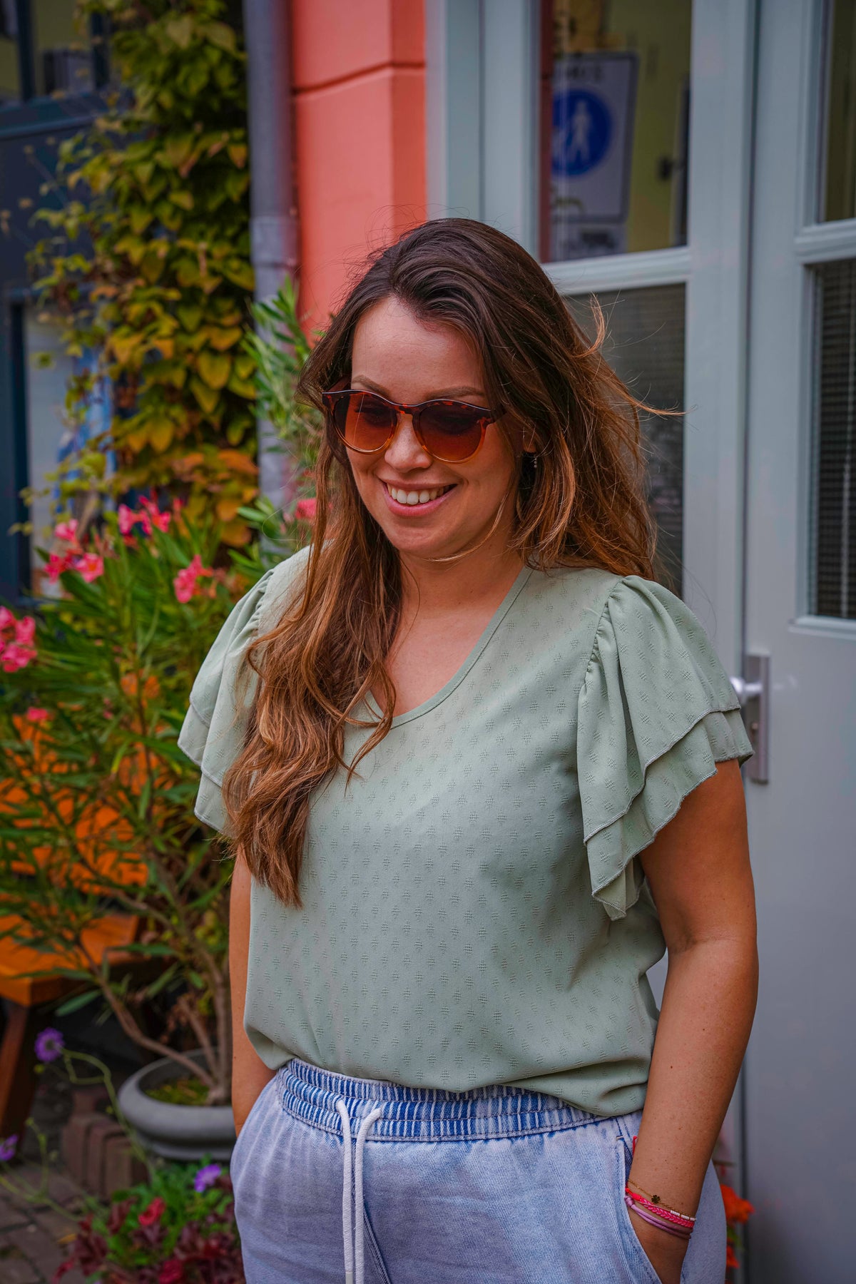 Vrouw met stijlvolle zonnebril en lichte blouse, perfect voor zomerse dagen