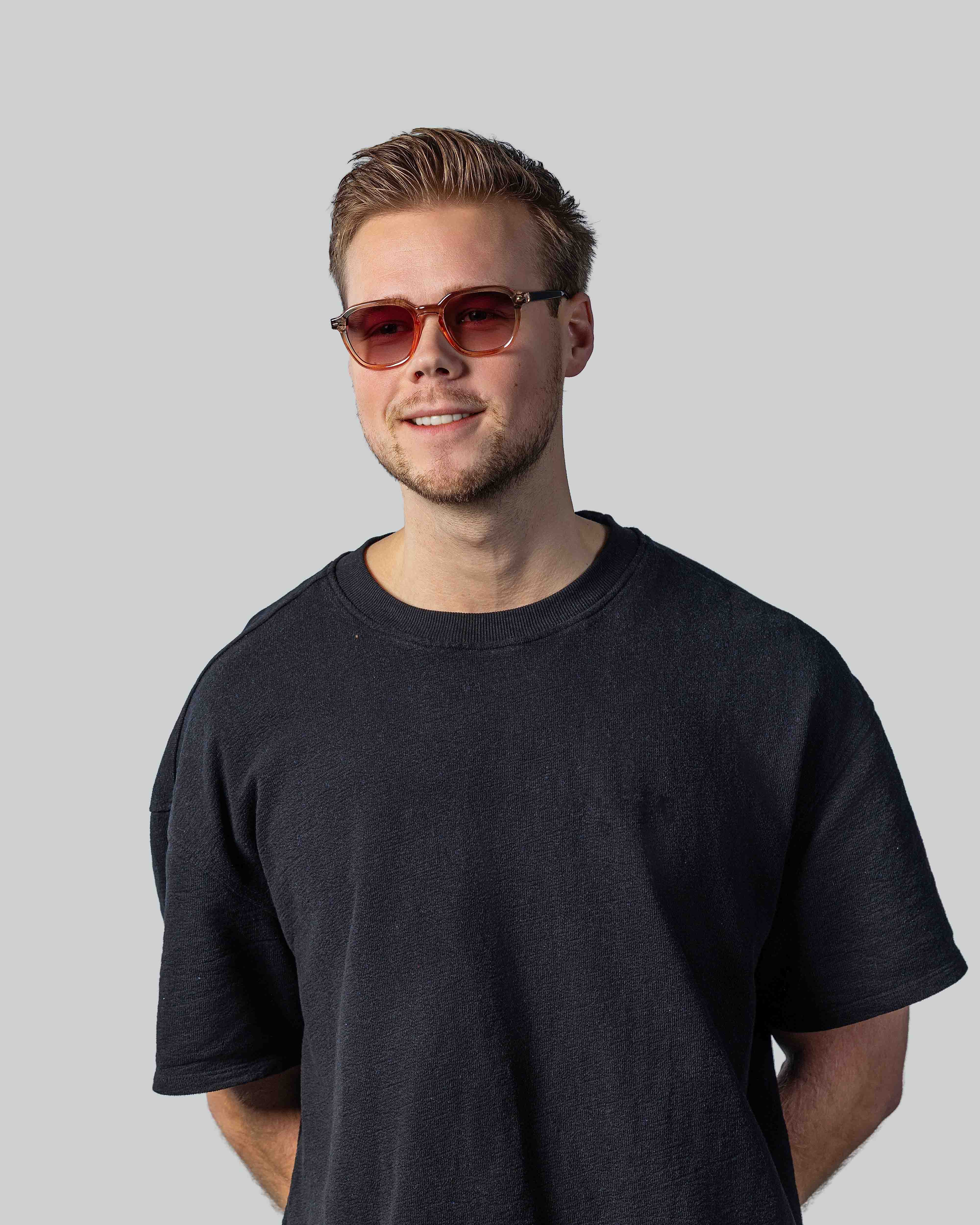 Man met stijlvolle zonnebril en donkere t-shirt, perfect voor zomerse dagen