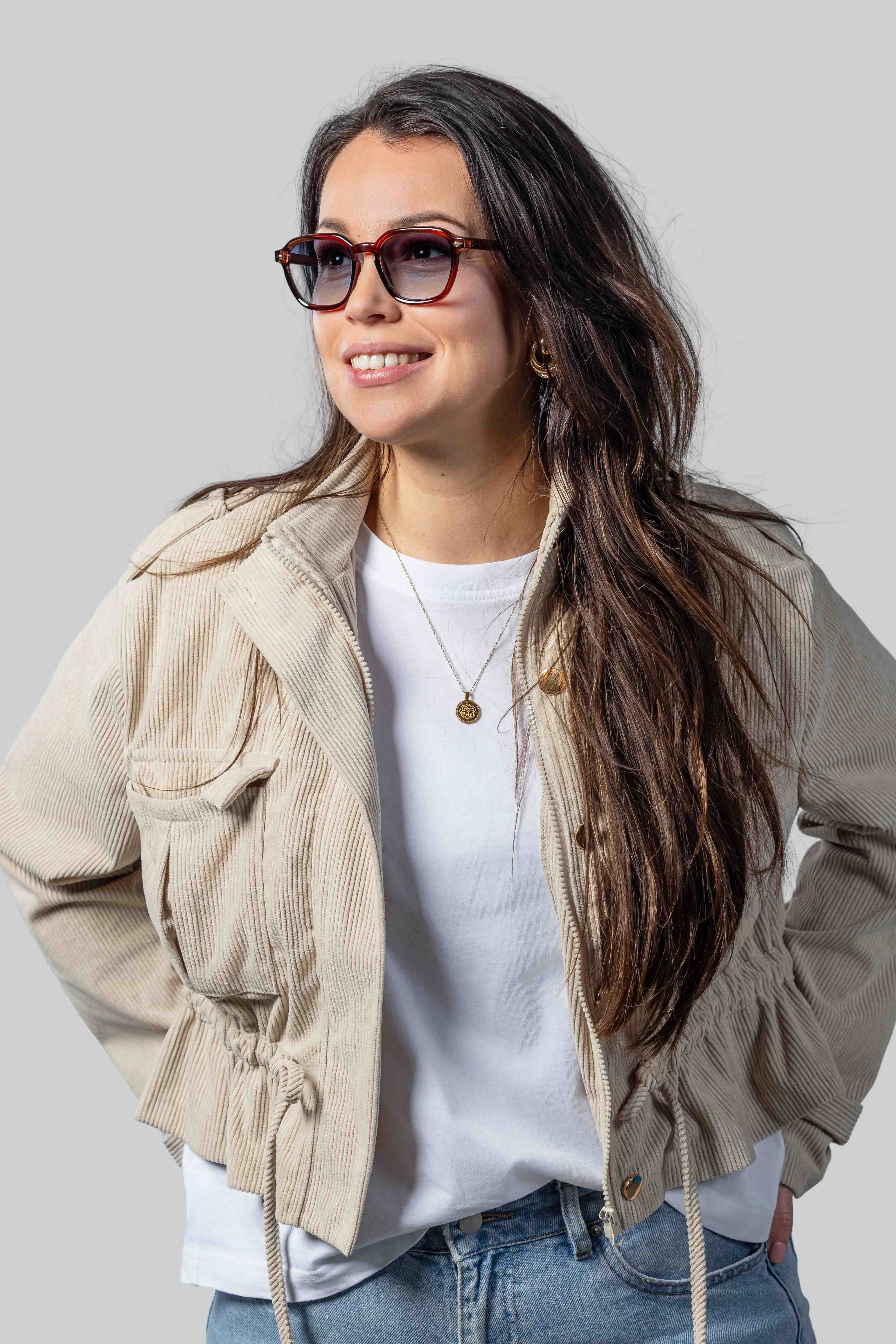 Vrouw met stijlvolle zonnebril, beige jas en witte t-shirt, perfect voor dagelijks dragen