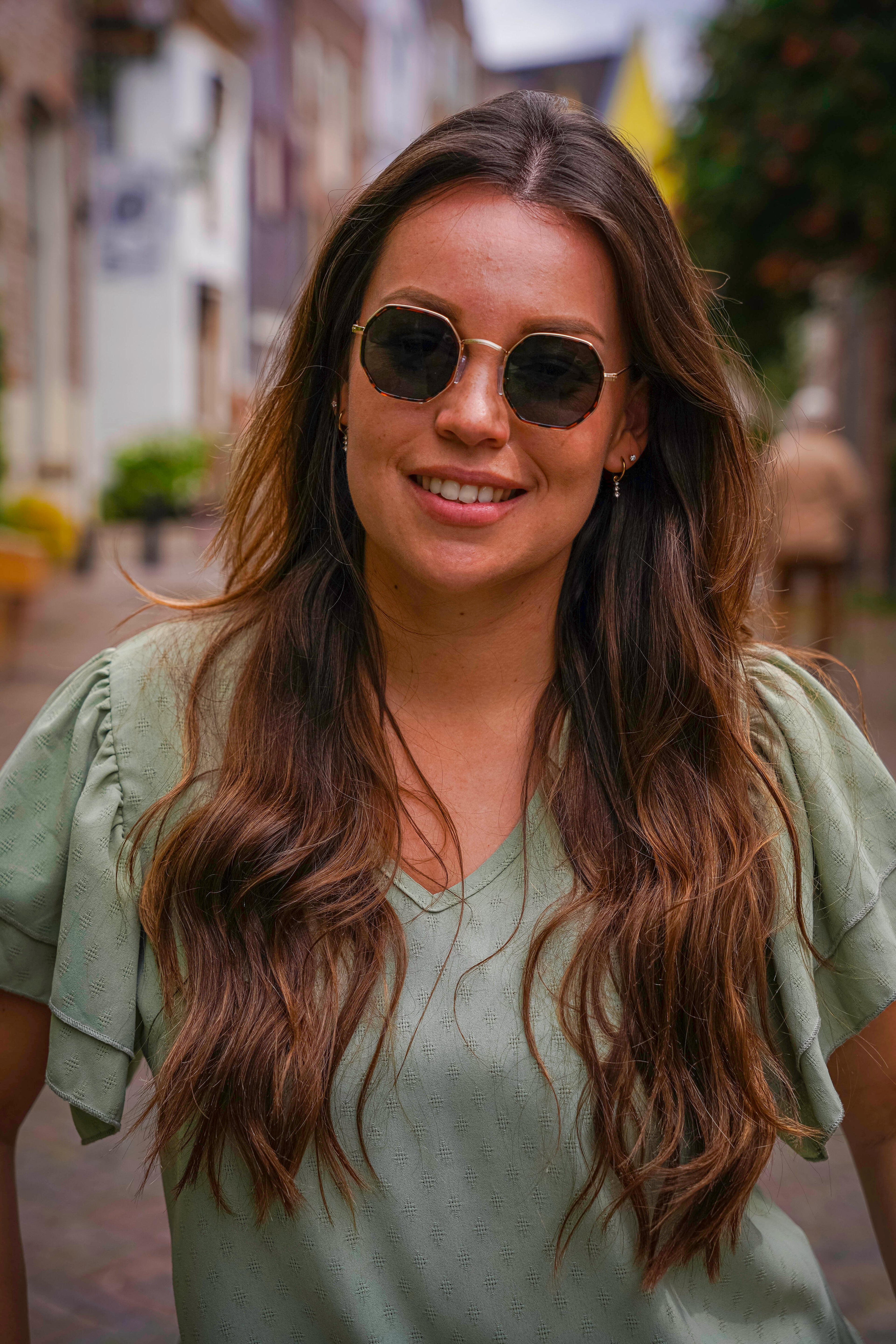 Vrouw met stijlvolle zonnebril en lang bruin haar, perfect voor zonnige dagen