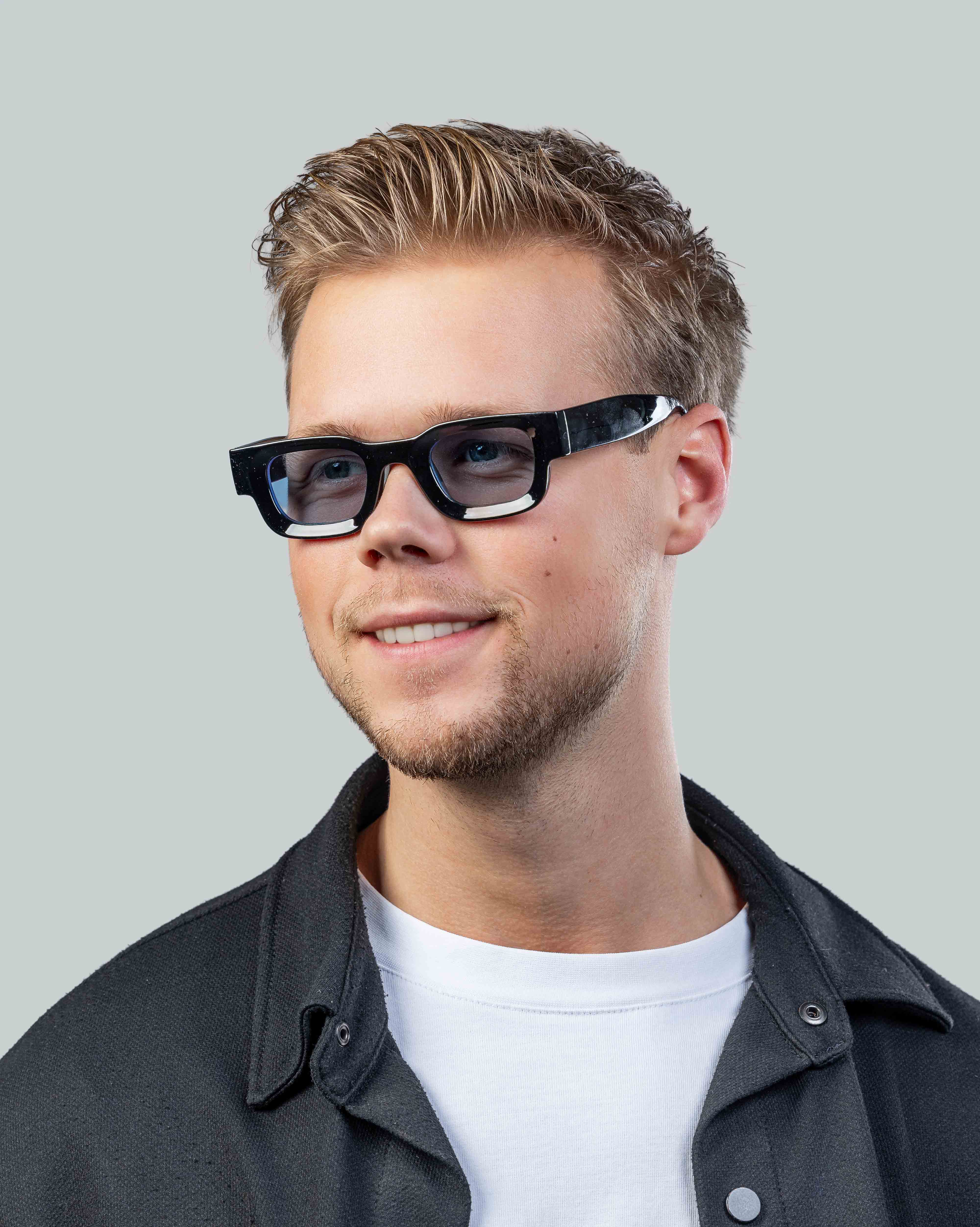 Stijlvolle zonnebril met zwarte montuur gedragen door man, perfect voor dagelijks gebruik en zonbescherming.