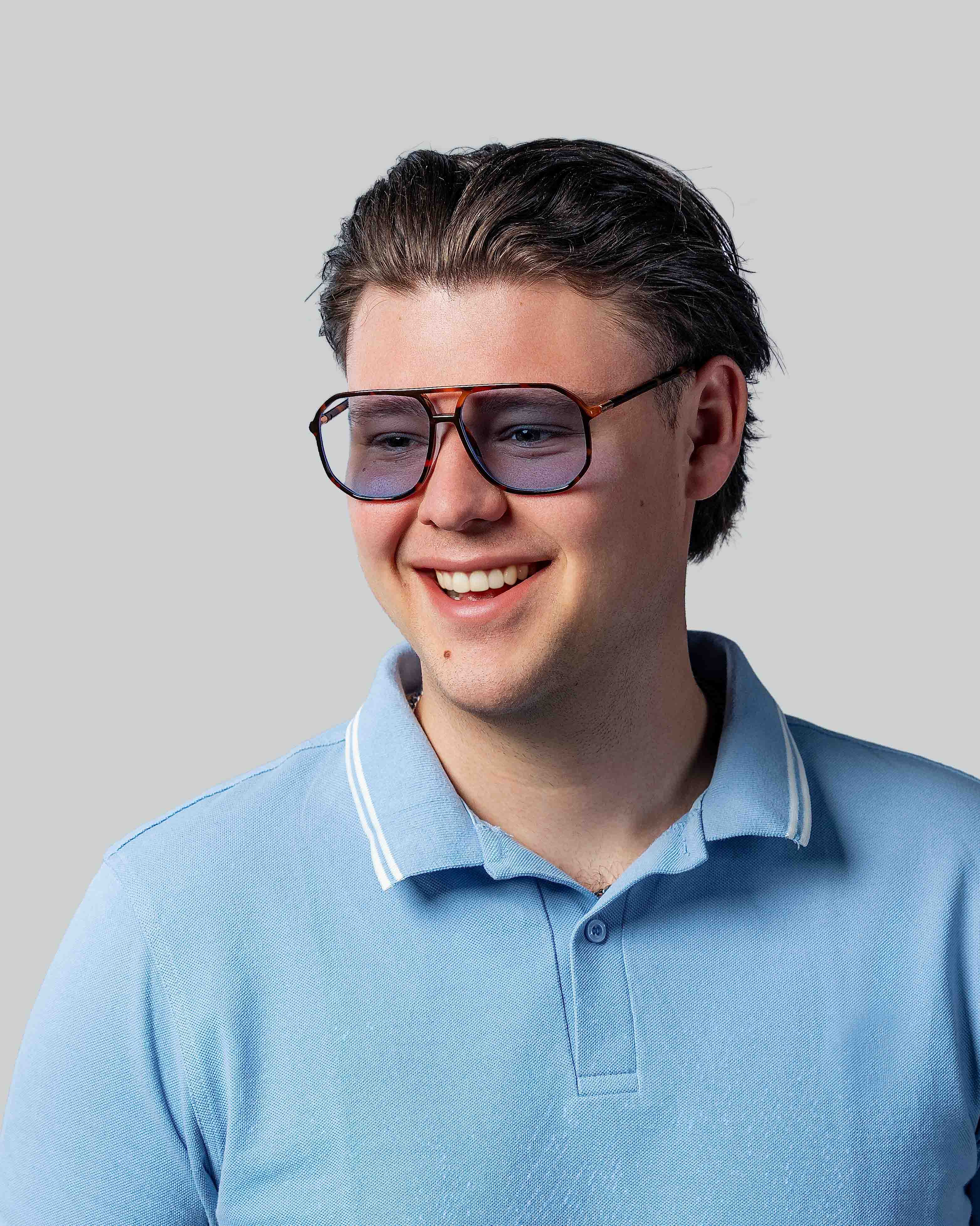 Man met stijlvolle zonnebril en lichtblauw poloshirt, perfect voor een zonnige dag