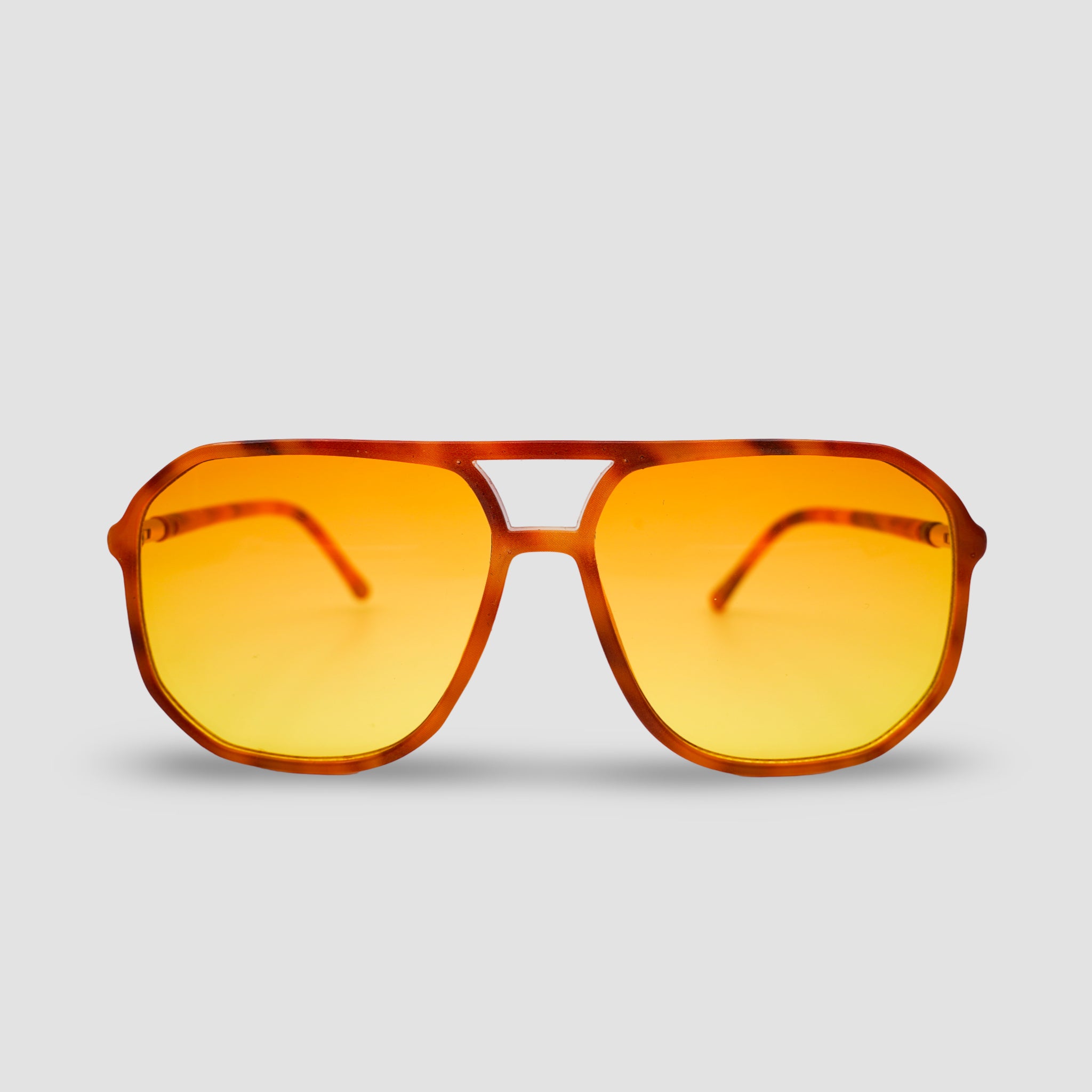 Stijlvolle zonnebril met amber glazen en tortoise frame, perfect voor zomerse dagen