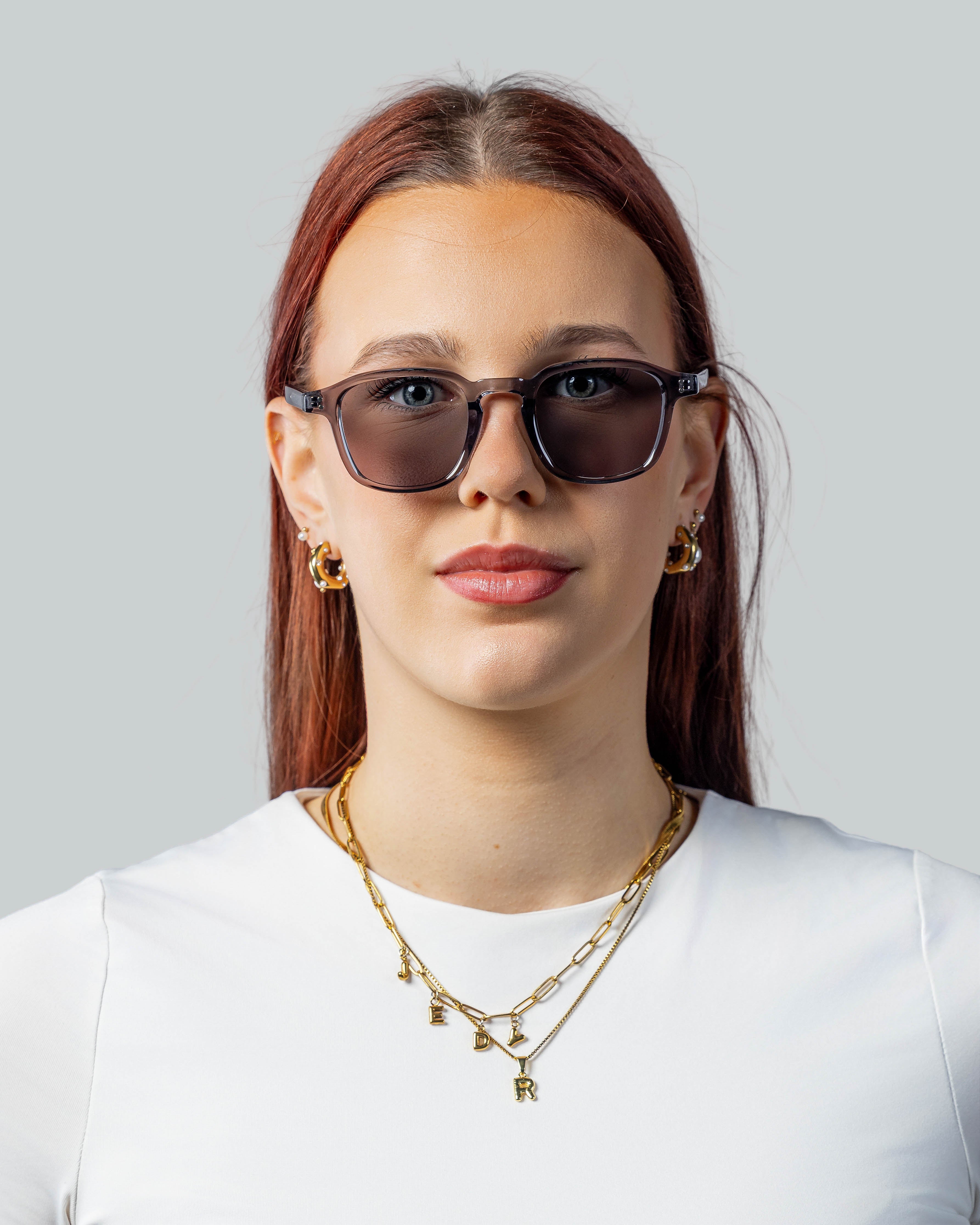 Vrouw met stijlvolle zonnebril en gouden sieraden, perfect voor een modieuze look