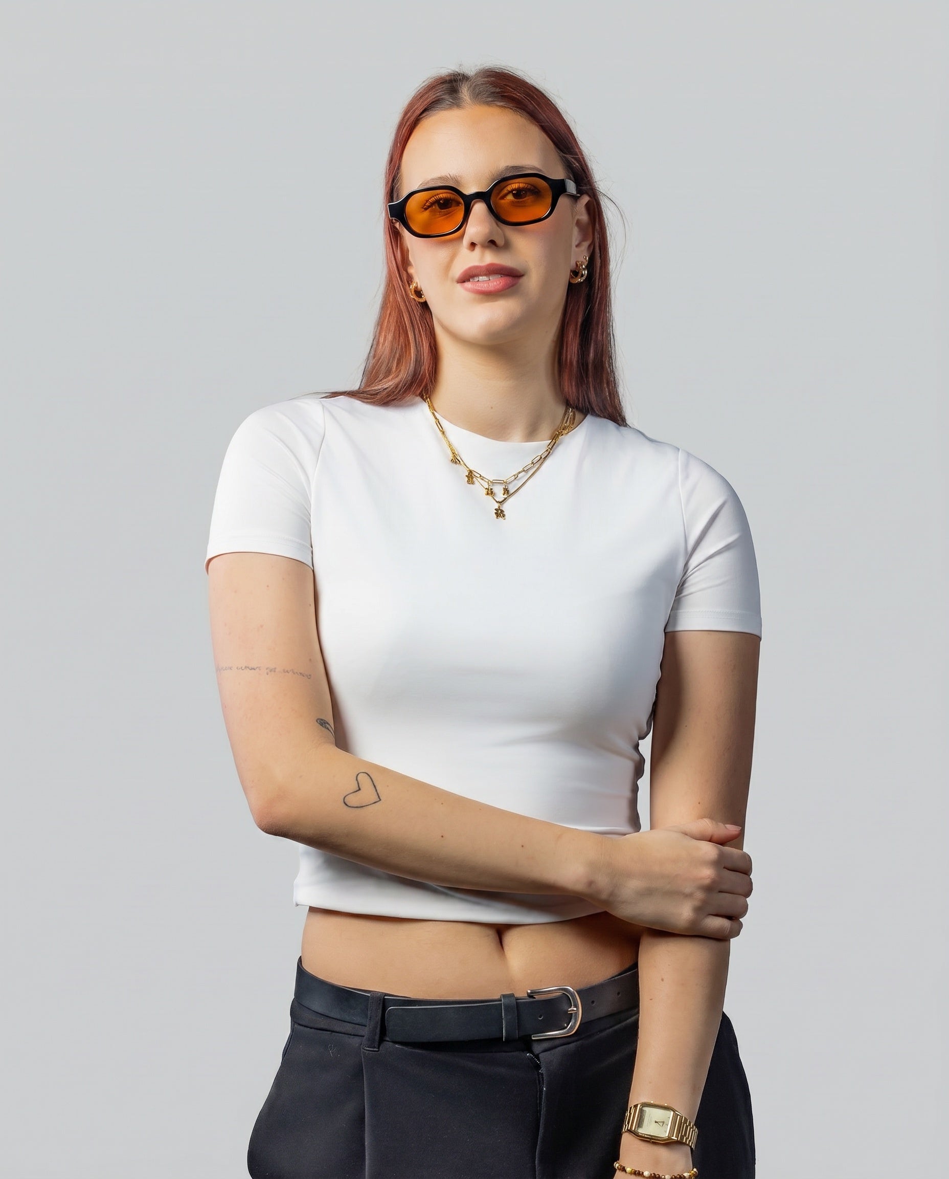 Vrouw met stijlvolle zonnebril met oranje glazen en zwarte montuur, perfect voor een trendy look.