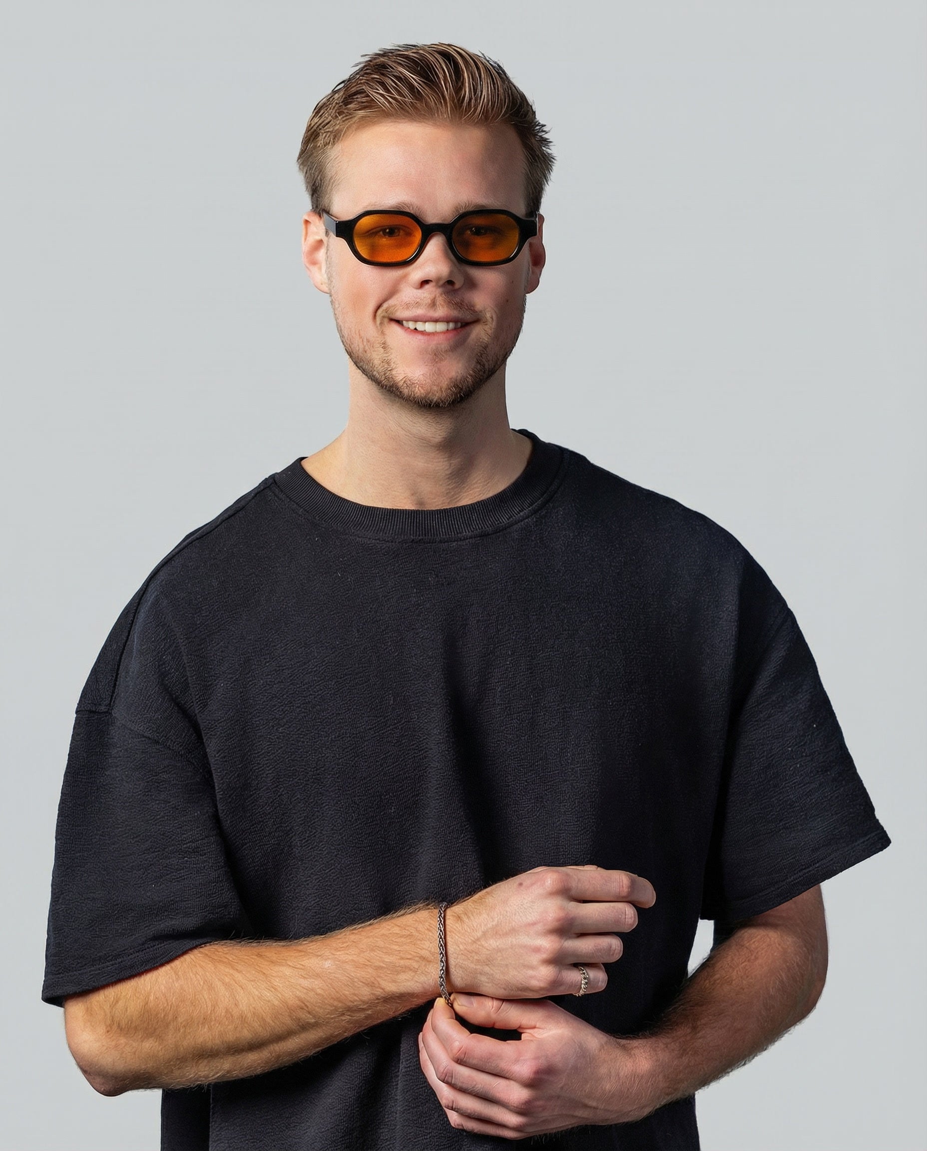 Man met stijlvolle zonnebril met oranje glazen en zwarte montuur, perfect voor dagelijks gebruik